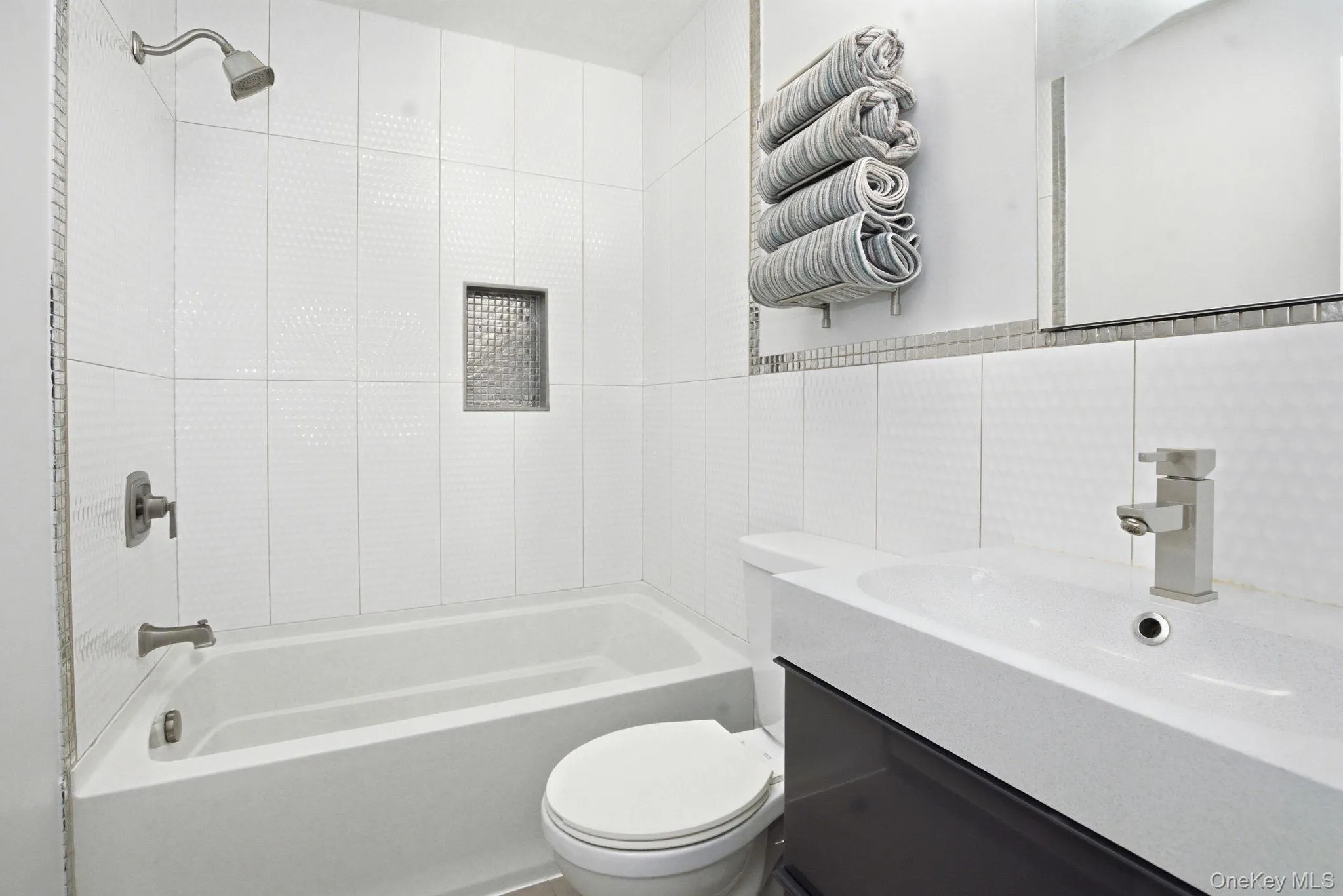 The updated full bath features crisp tilework, a sleek vanity, and a clean, modern finish. The updated full bath features crisp tilework, a sleek vanity, and a clean, modern finish.