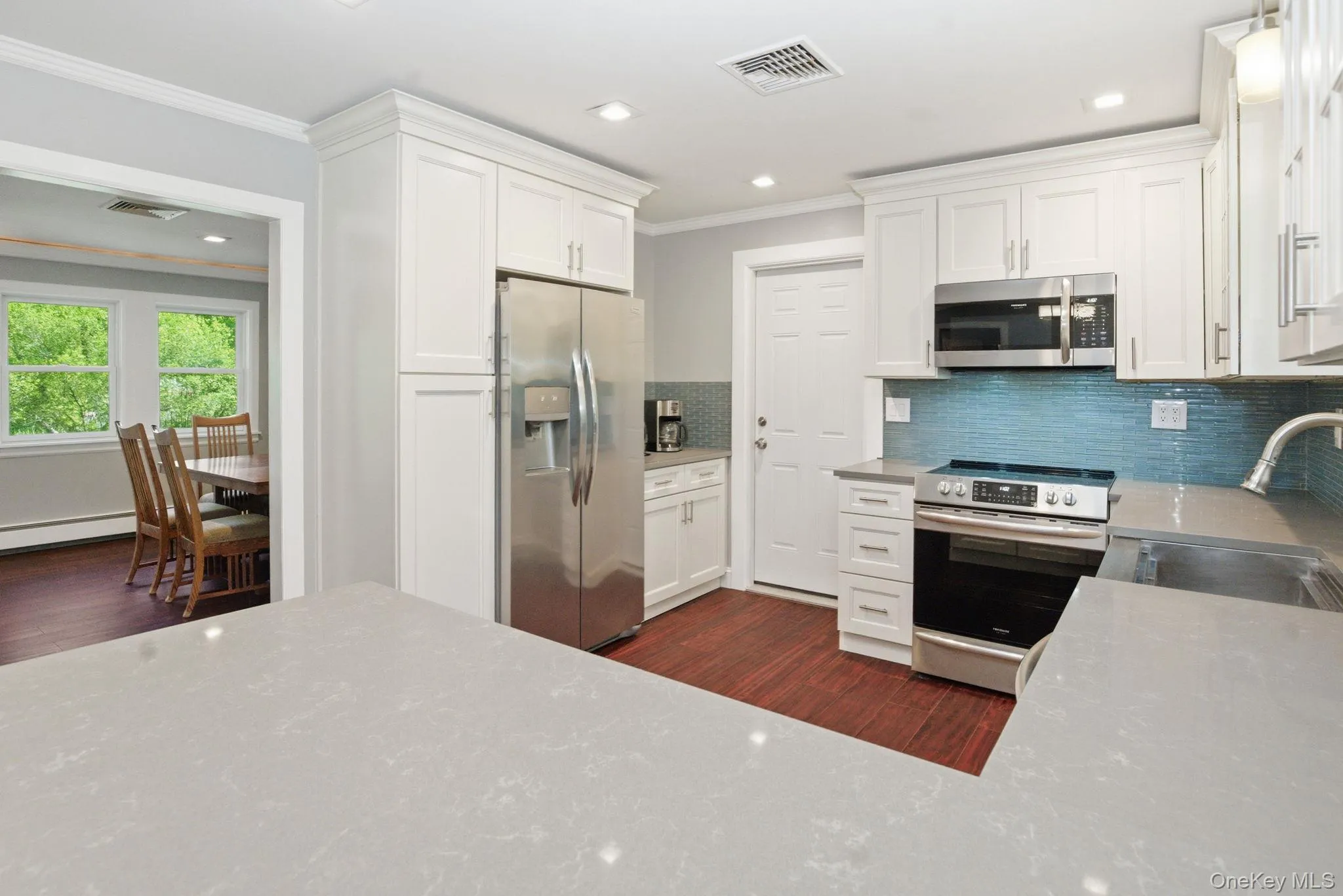 Generous counter space and modern finishes open right to the dining room, perfect for cooking and gathering. Generous counter space and modern finishes open right to the dining room, perfect for cooking and gathering.