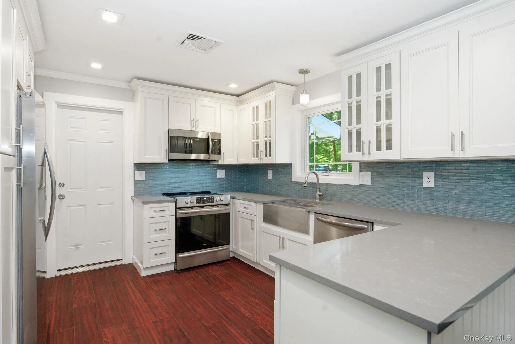 Stainless steel appliances and a deep farmhouse sink make this updated kitchen as functional as it is beautiful. Stainless steel appliances and a deep farmhouse sink make this updated kitchen as functional as it is beautiful.