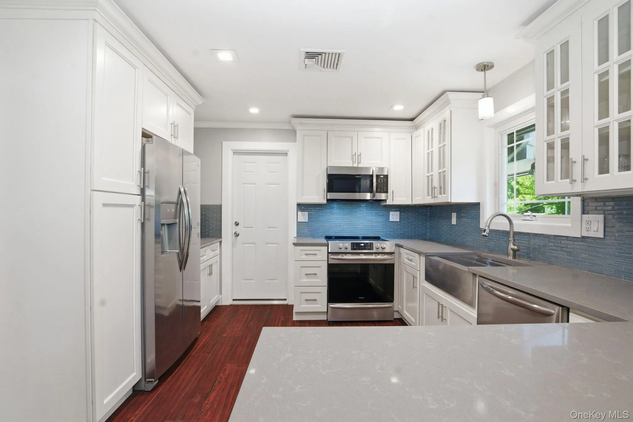 Thoughtfully updated from top to bottom, this kitchen blends timeless white cabinetry with sleek quartz and stainless. Thoughtfully updated from top to bottom, this kitchen blends timeless white cabinetry with sleek quartz and stainless.