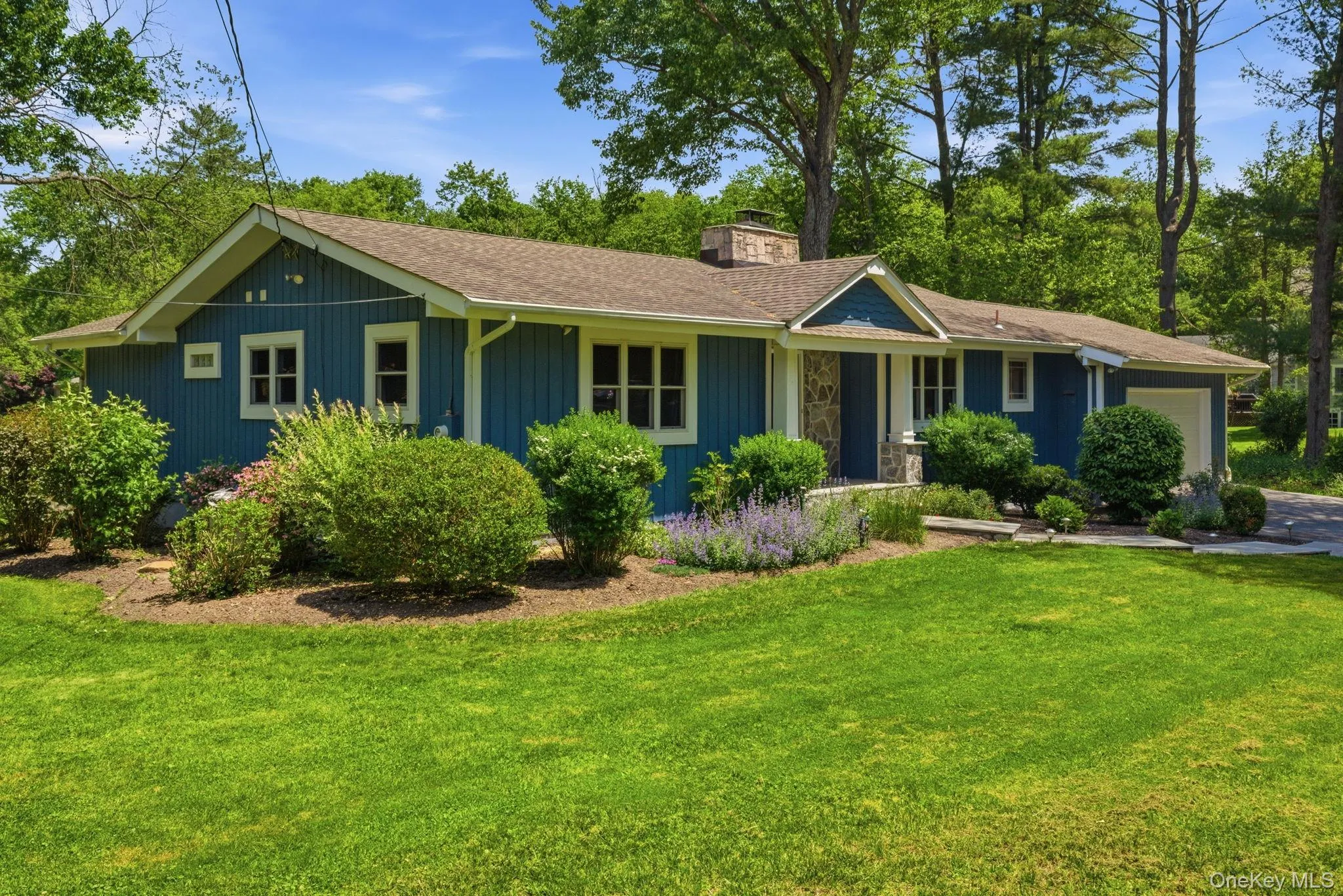 Lush, layered landscaping and a classic board-and-batten exterior give this single-level home curb appeal that turns heads. Lush, layered landscaping and a classic board-and-batten exterior give this single-level home curb appeal that turns heads.