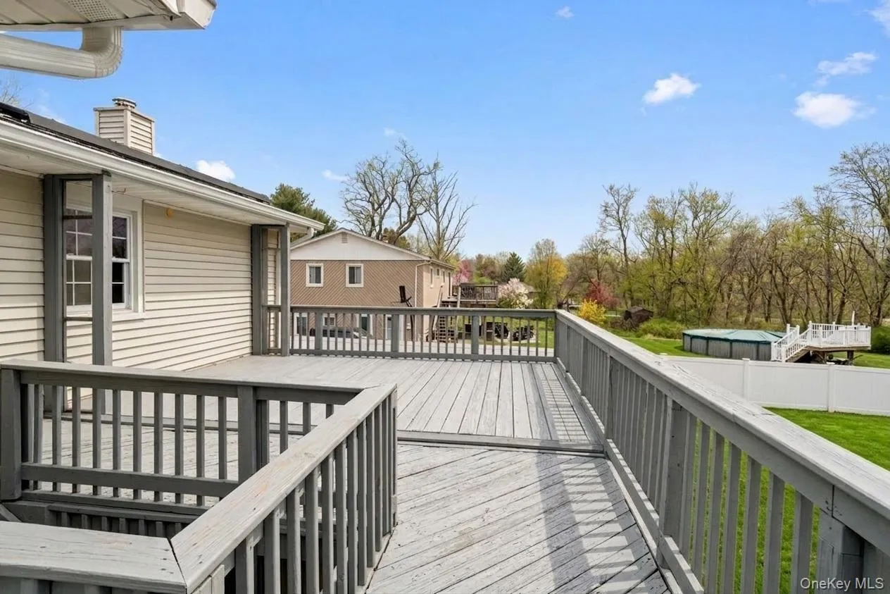 Expansive outdoor deck featuring wood-finish flooring and railing Expansive outdoor deck featuring wood-finish flooring and railing