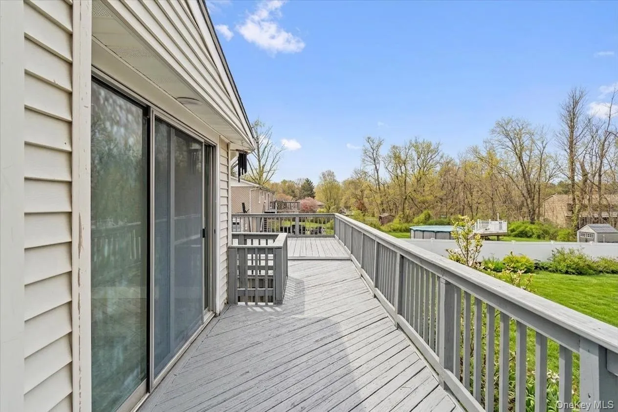 Expansive outdoor deck featuring wood-finish flooring and a full railing system Expansive outdoor deck featuring wood-finish flooring and a full railing system