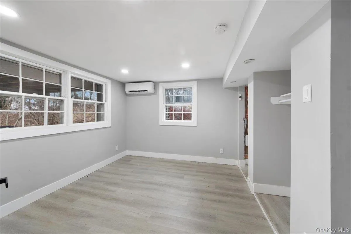 Den (basement) with neutral gray walls complemented by light wood-finish flooring Den (basement) with neutral gray walls complemented by light wood-finish flooring