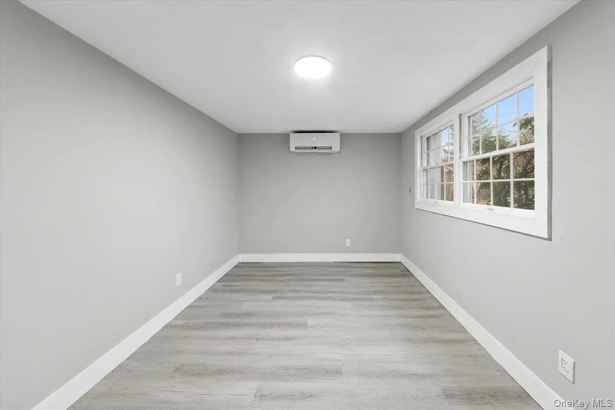 Bright 4th bedroom (basement) with wood-finish flooring and light gray walls Bright 4th bedroom (basement) with wood-finish flooring and light gray walls