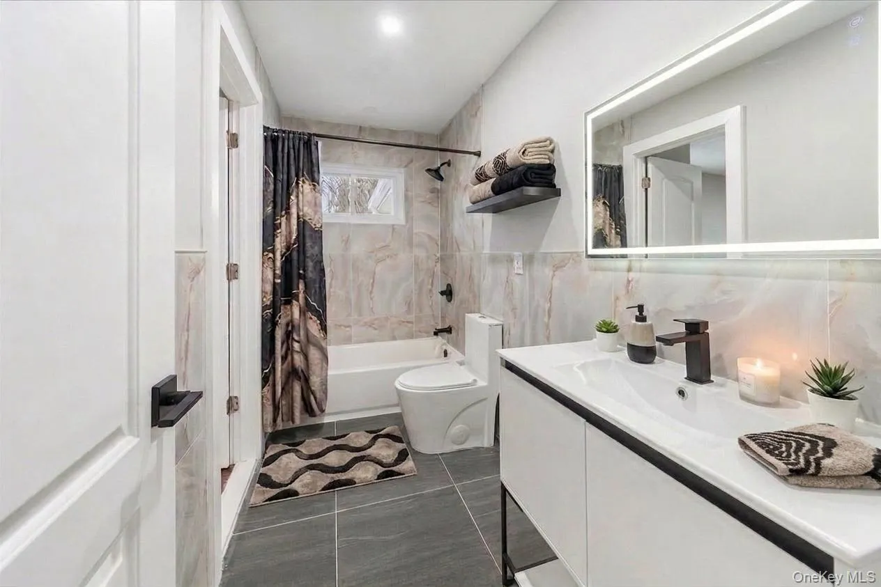 Staged main floor full bathroom; entrance from both primary bedroom and the hallway. Staged main floor full bathroom; entrance from both primary bedroom and the hallway.