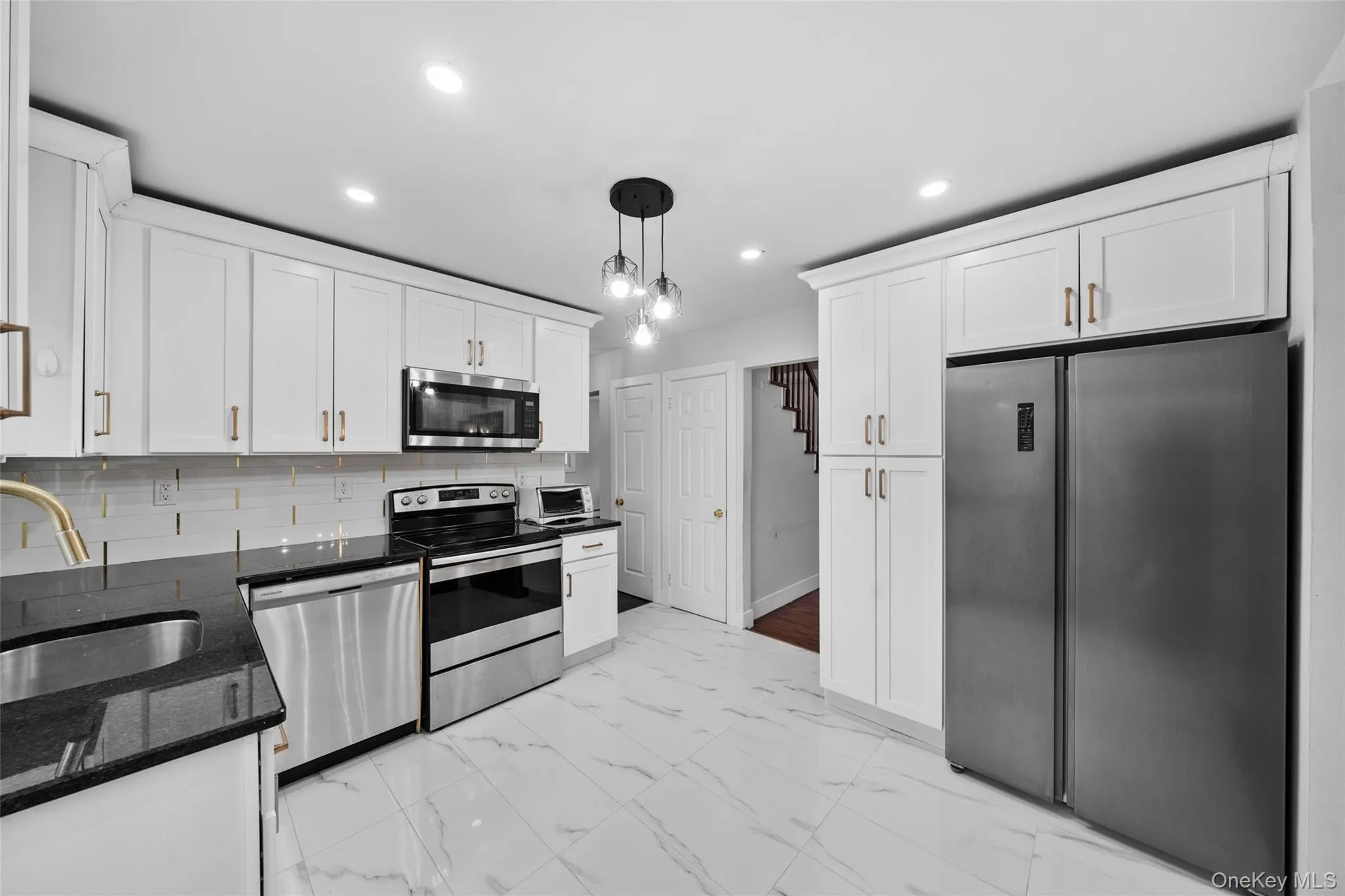 Kitchen featuring a sink, marble finish floor, white cabinetry, and stainless steel appliances Kitchen featuring a sink, marble finish floor, white cabinetry, and stainless steel appliances