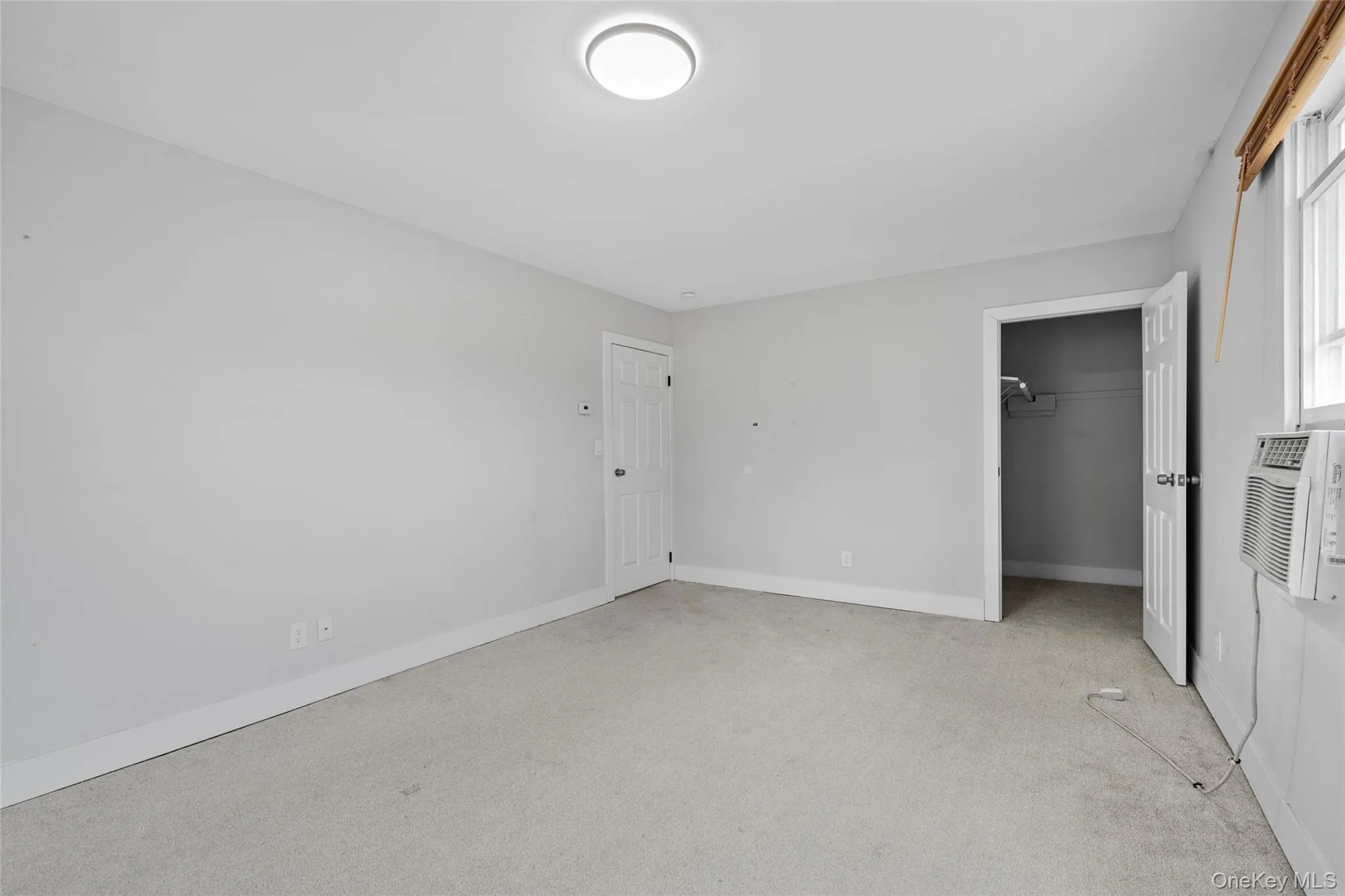 Unfurnished bedroom featuring baseboards and light carpet Unfurnished bedroom featuring baseboards and light carpet