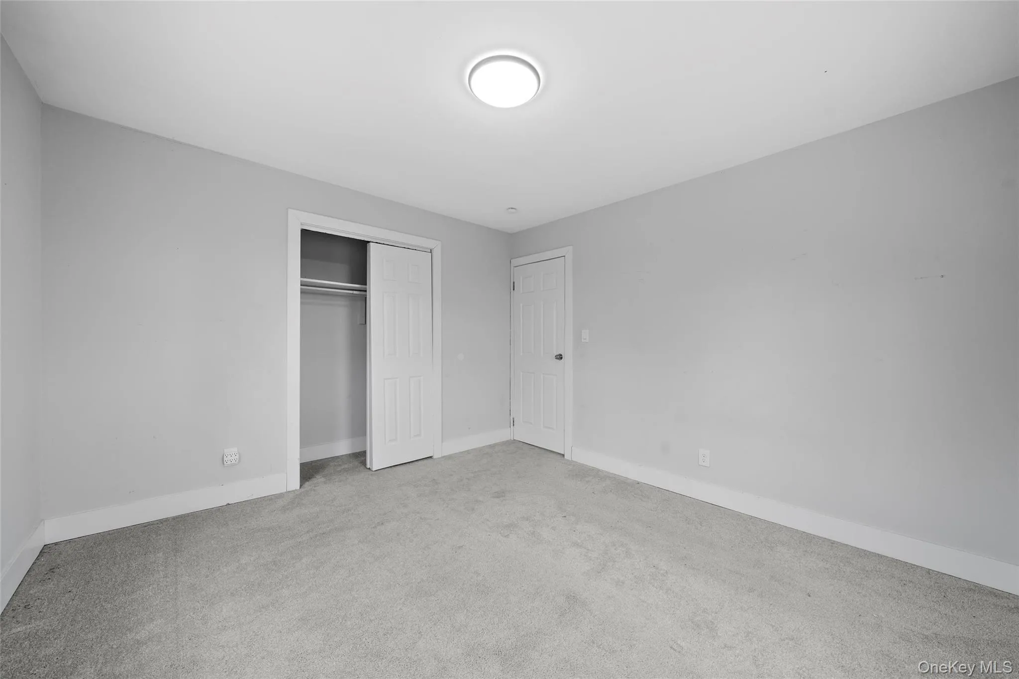 Unfurnished bedroom with baseboards, a closet, and carpet floors Unfurnished bedroom with baseboards, a closet, and carpet floors