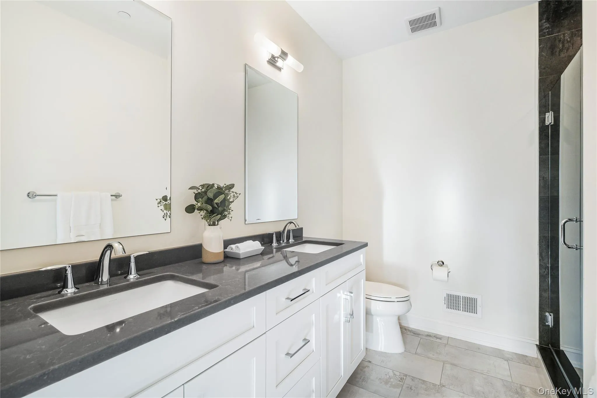 Bathroom with vanity, a shower with door, and toilet Bathroom with vanity, a shower with door, and toilet