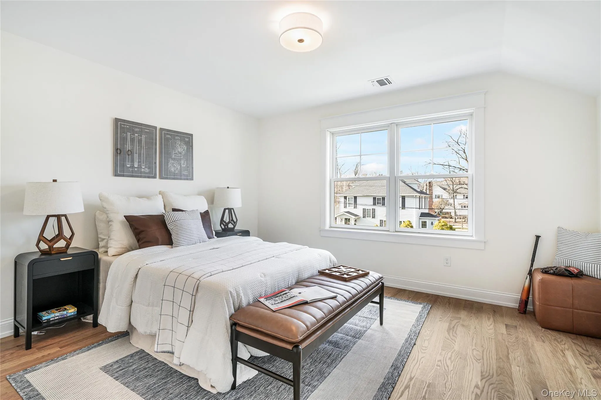 Bedroom featuring vaulted ceiling and light hardwood / wood-style floors Bedroom featuring vaulted ceiling and light hardwood / wood-style floors