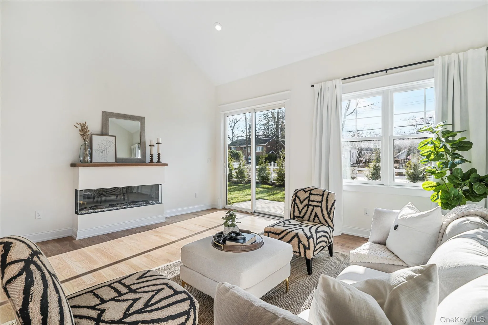 Living room featuring light hardwood / wood-style flooring and high vaulted ceiling Living room featuring light hardwood / wood-style flooring and high vaulted ceiling