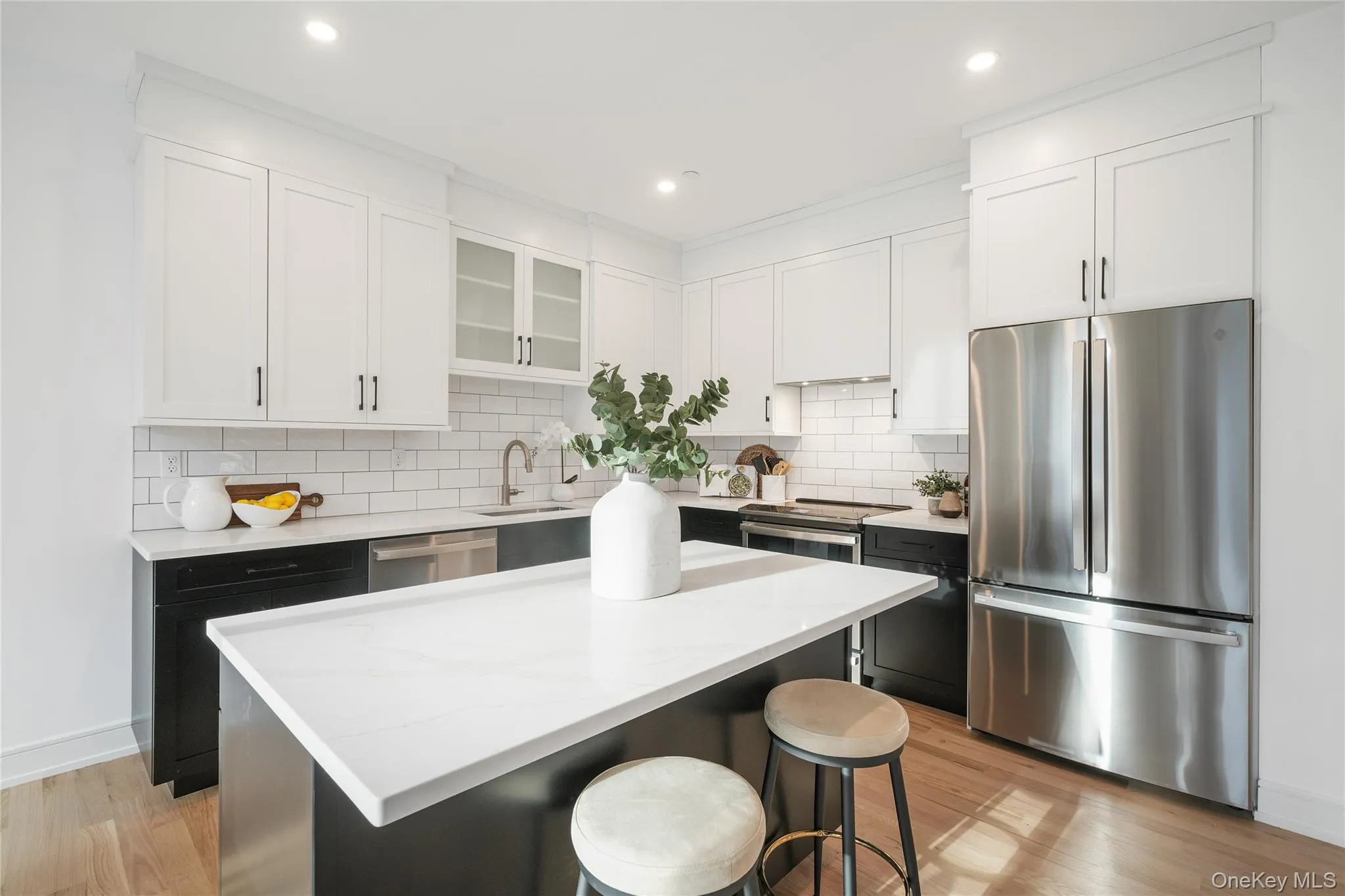 Kitchen featuring stainless steel appliances, a kitchen breakfast bar, white cabinets, and a kitchen island Kitchen featuring stainless steel appliances, a kitchen breakfast bar, white cabinets, and a kitchen island