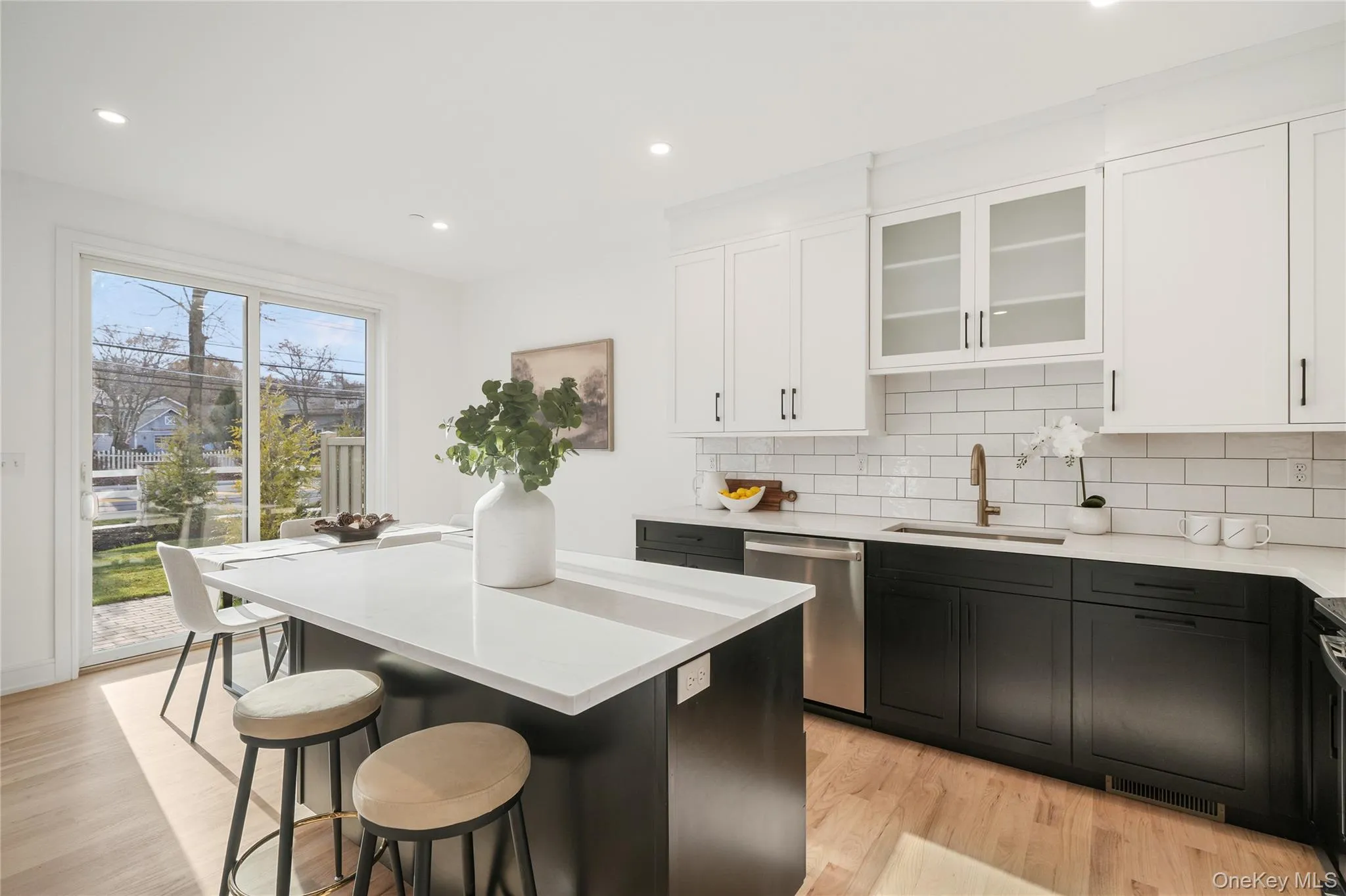 Kitchen featuring sink, a breakfast bar area, dishwasher, a kitchen island, and decorative backsplash Kitchen featuring sink, a breakfast bar area, dishwasher, a kitchen island, and decorative backsplash
