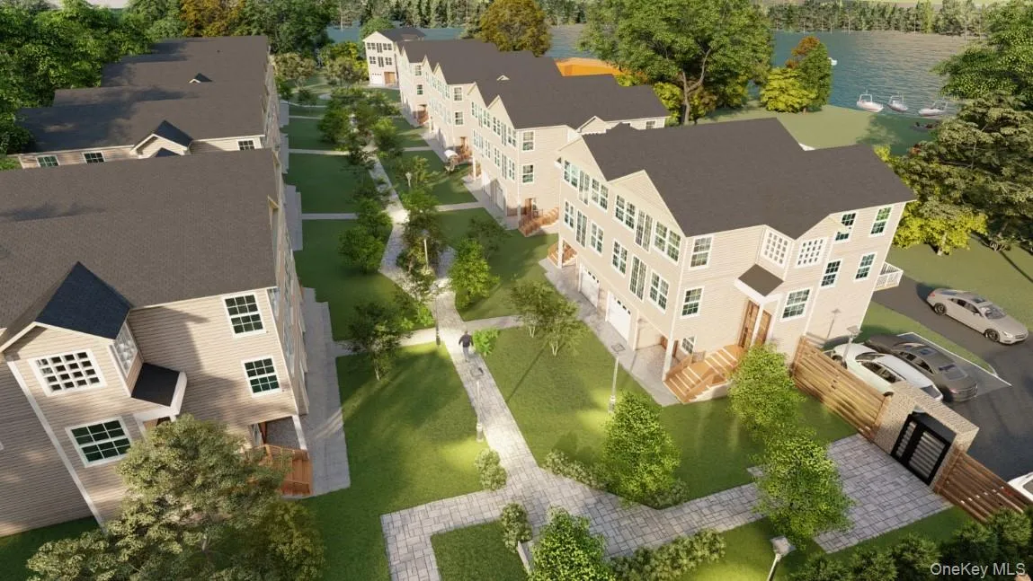 Multi-level townhome development featuring light-toned siding, dark roofing, and multiple windows Multi-level townhome development featuring light-toned siding, dark roofing, and multiple windows