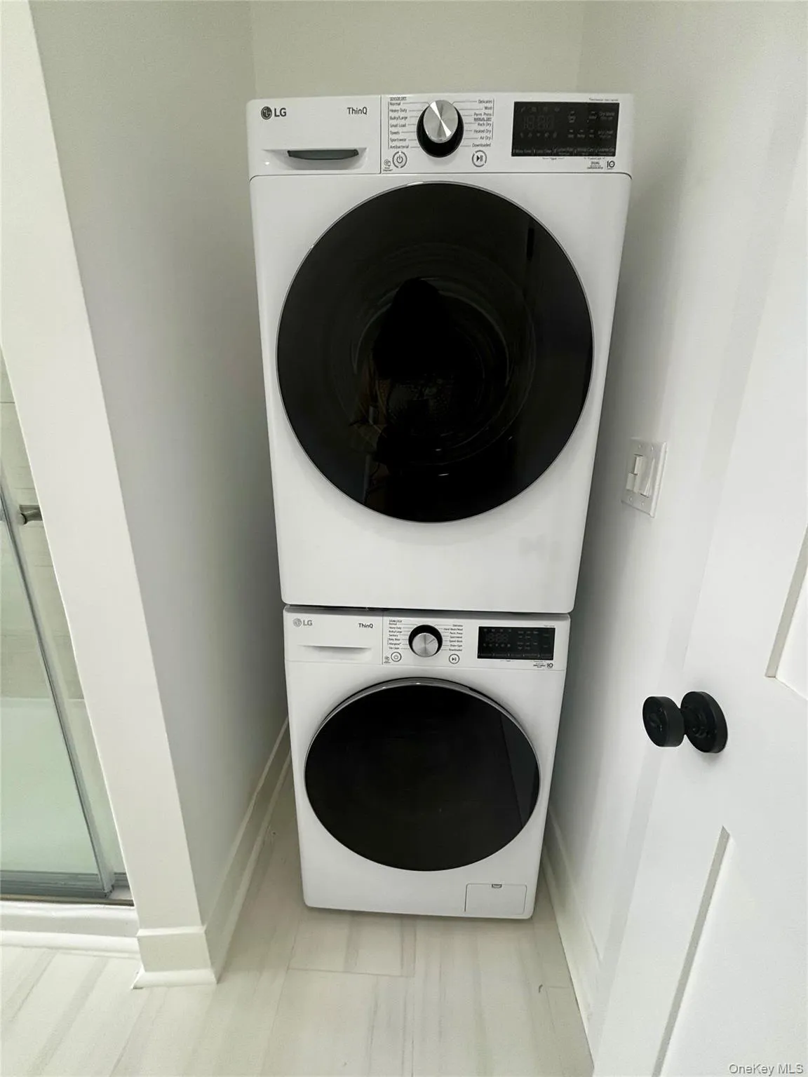 Washroom featuring stacked washer and clothes dryer and baseboards Washroom featuring stacked washer and clothes dryer and baseboards