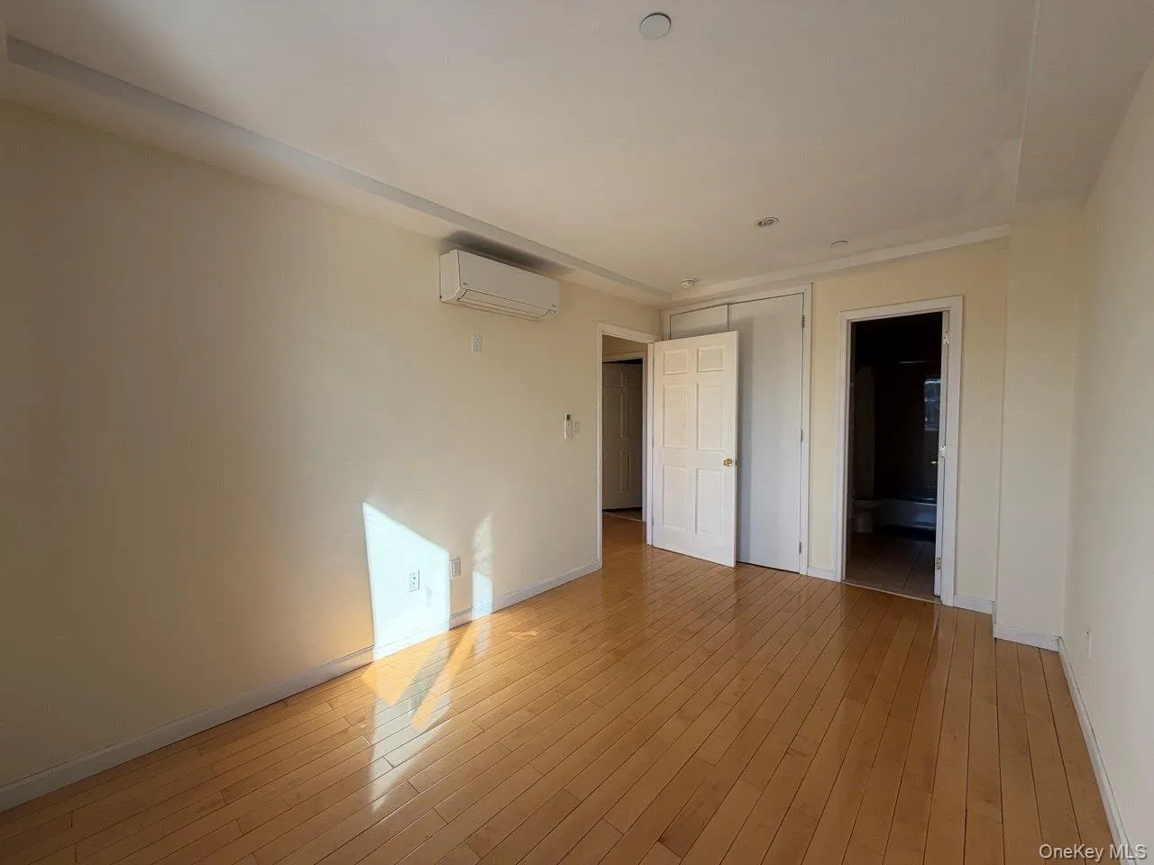 Spacious interior featuring wood-finish flooring, light-toned walls, and recessed lighting Spacious interior featuring wood-finish flooring, light-toned walls, and recessed lighting