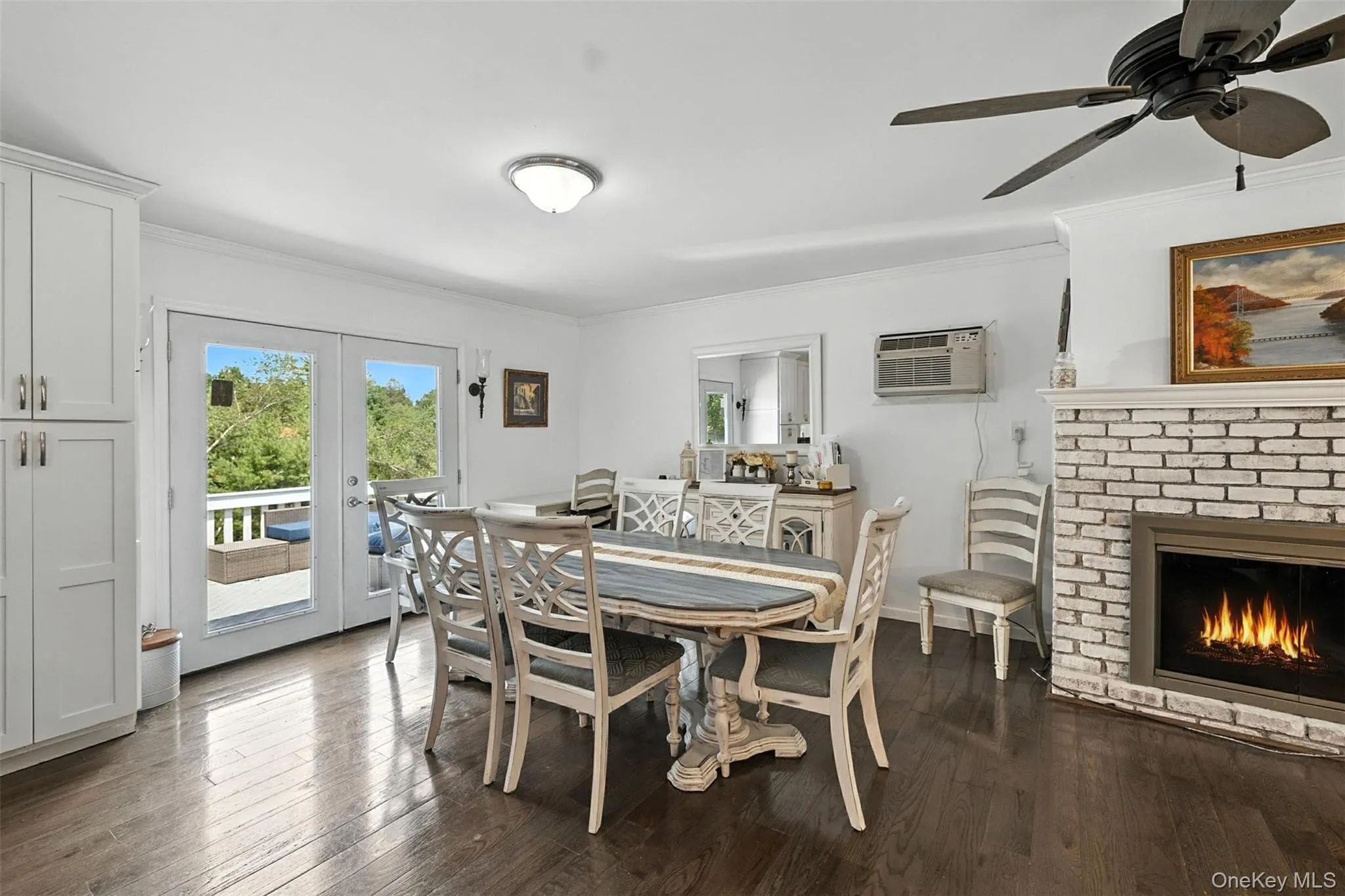 Dining space with ornamental molding, a fireplace, dark wood-type flooring, french doors, and ceiling fan Dining space with ornamental molding, a fireplace, dark wood-type flooring, french doors, and ceiling fan
