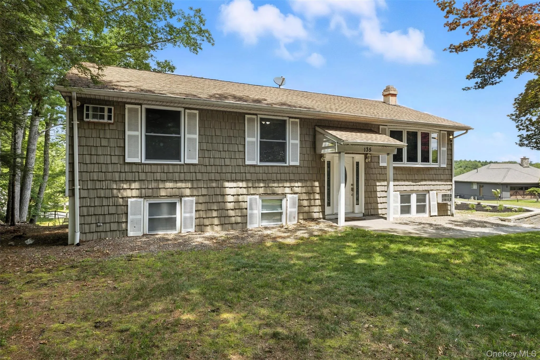 Bi-level home featuring a front yard, a chimney, and roof with shingles Bi-level home featuring a front yard, a chimney, and roof with shingles