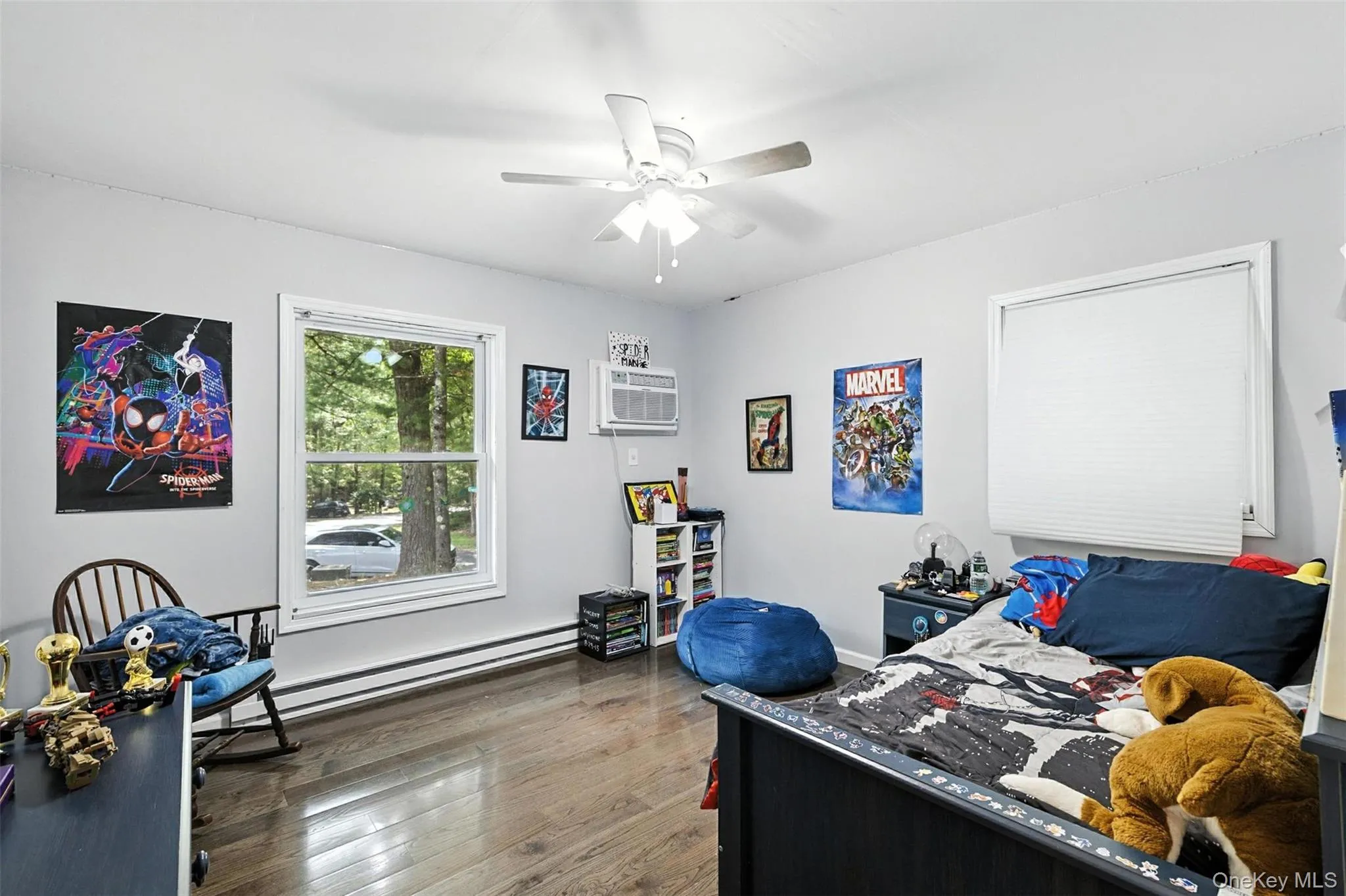 Office with baseboard heating, wood finished floors, a ceiling fan, and an AC wall unit Office with baseboard heating, wood finished floors, a ceiling fan, and an AC wall unit