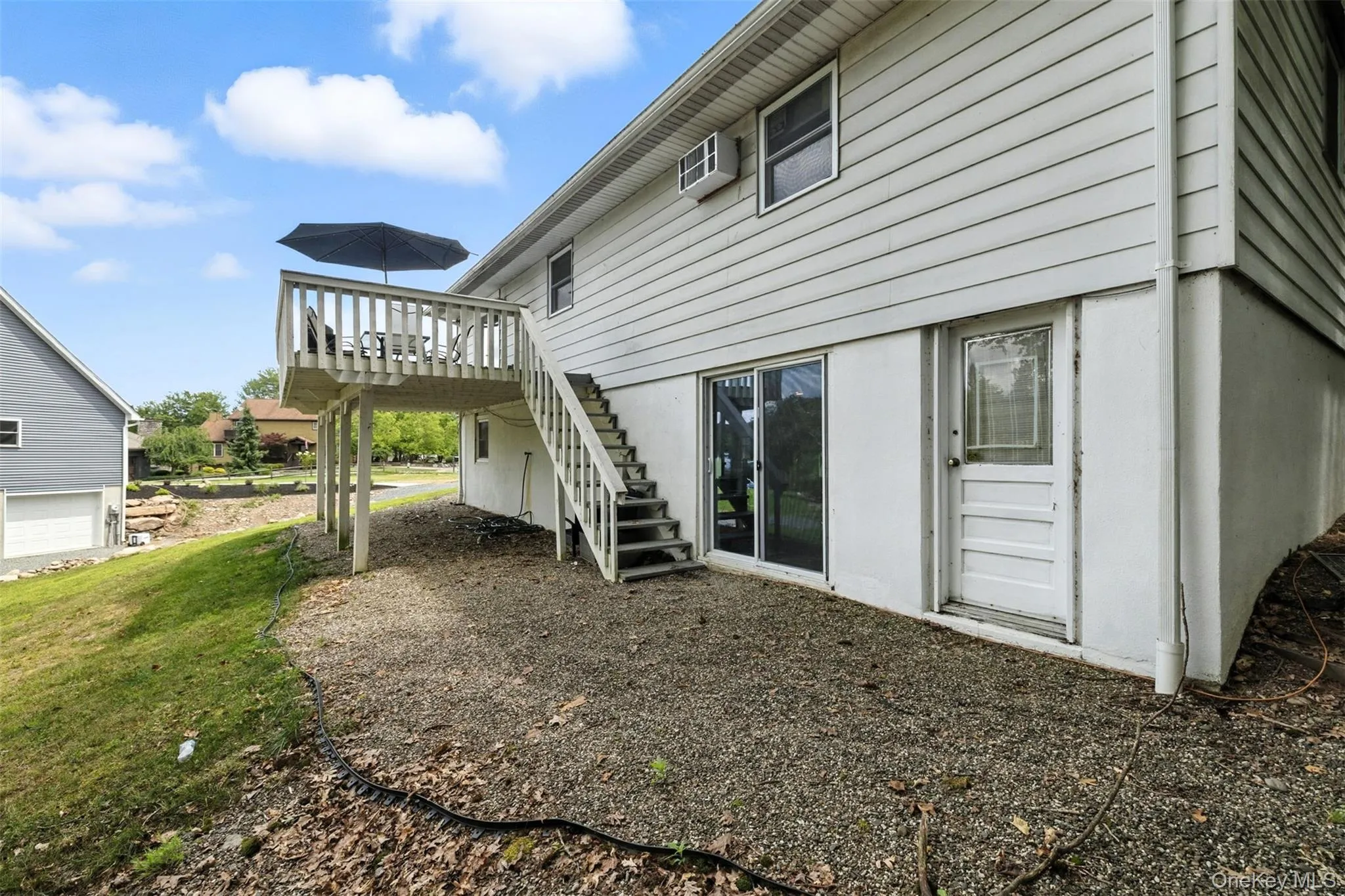 Back of house with stairway, a wooden deck, and a yard Back of house with stairway, a wooden deck, and a yard