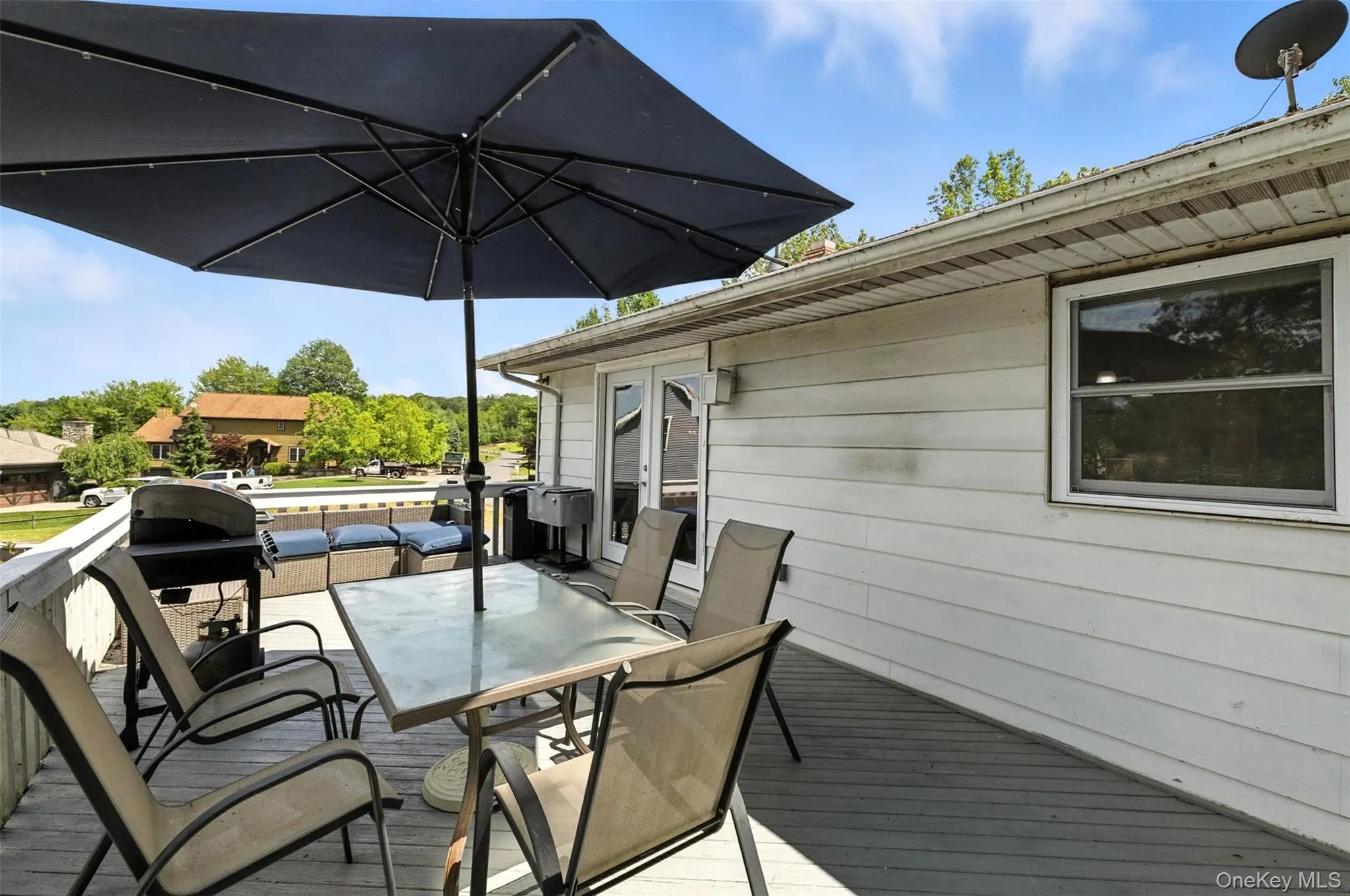 Wooden deck with outdoor dining space and area for grilling Wooden deck with outdoor dining space and area for grilling