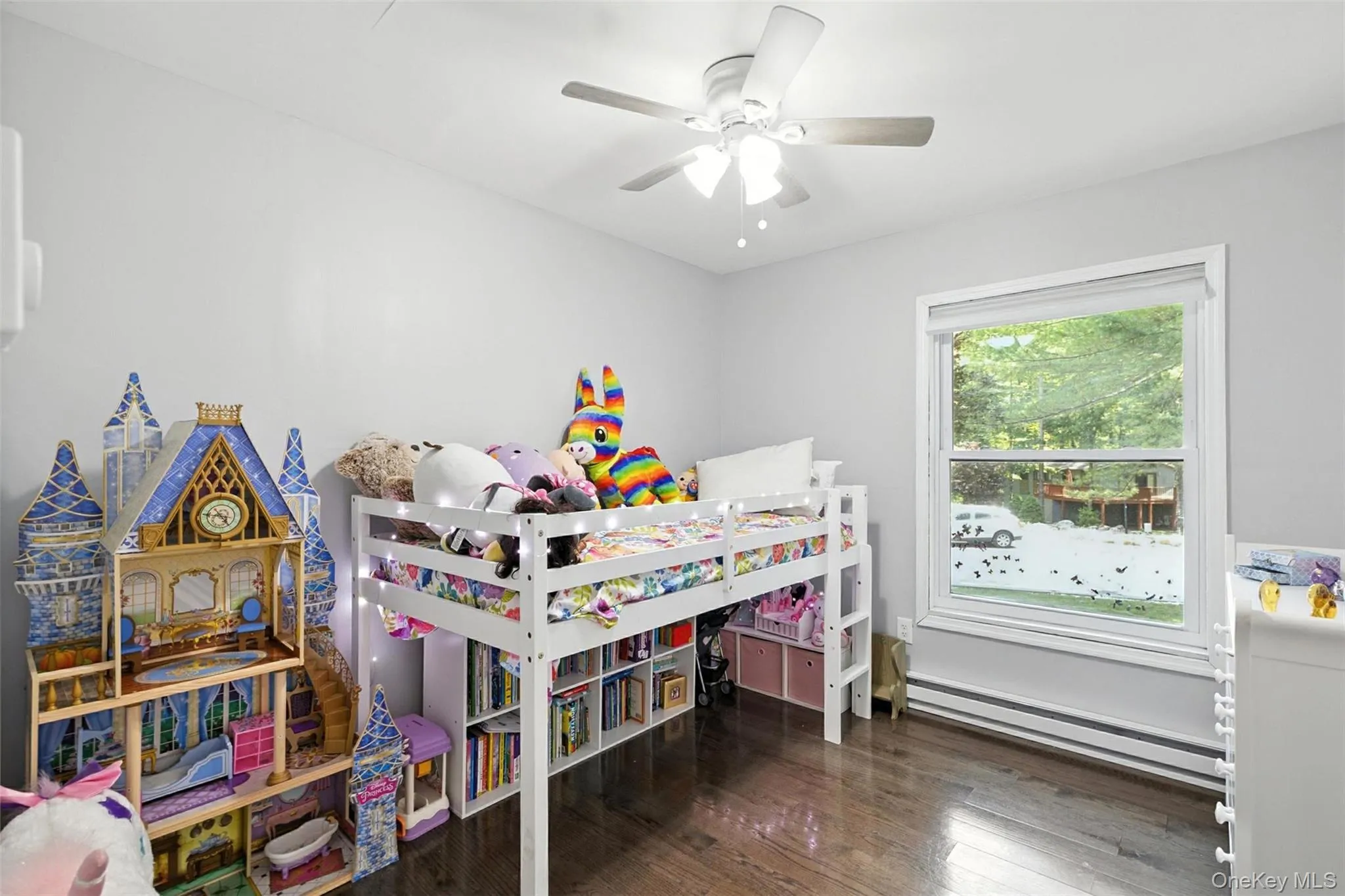 Bedroom with baseboard heating, wood finished floors, and a ceiling fan Bedroom with baseboard heating, wood finished floors, and a ceiling fan