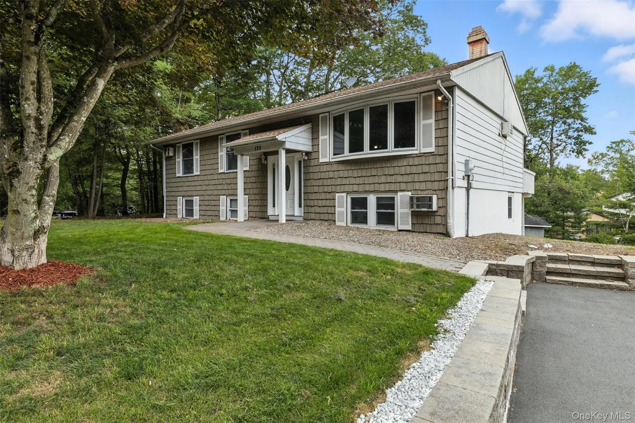Bi-level home with a front yard and a chimney Bi-level home with a front yard and a chimney
