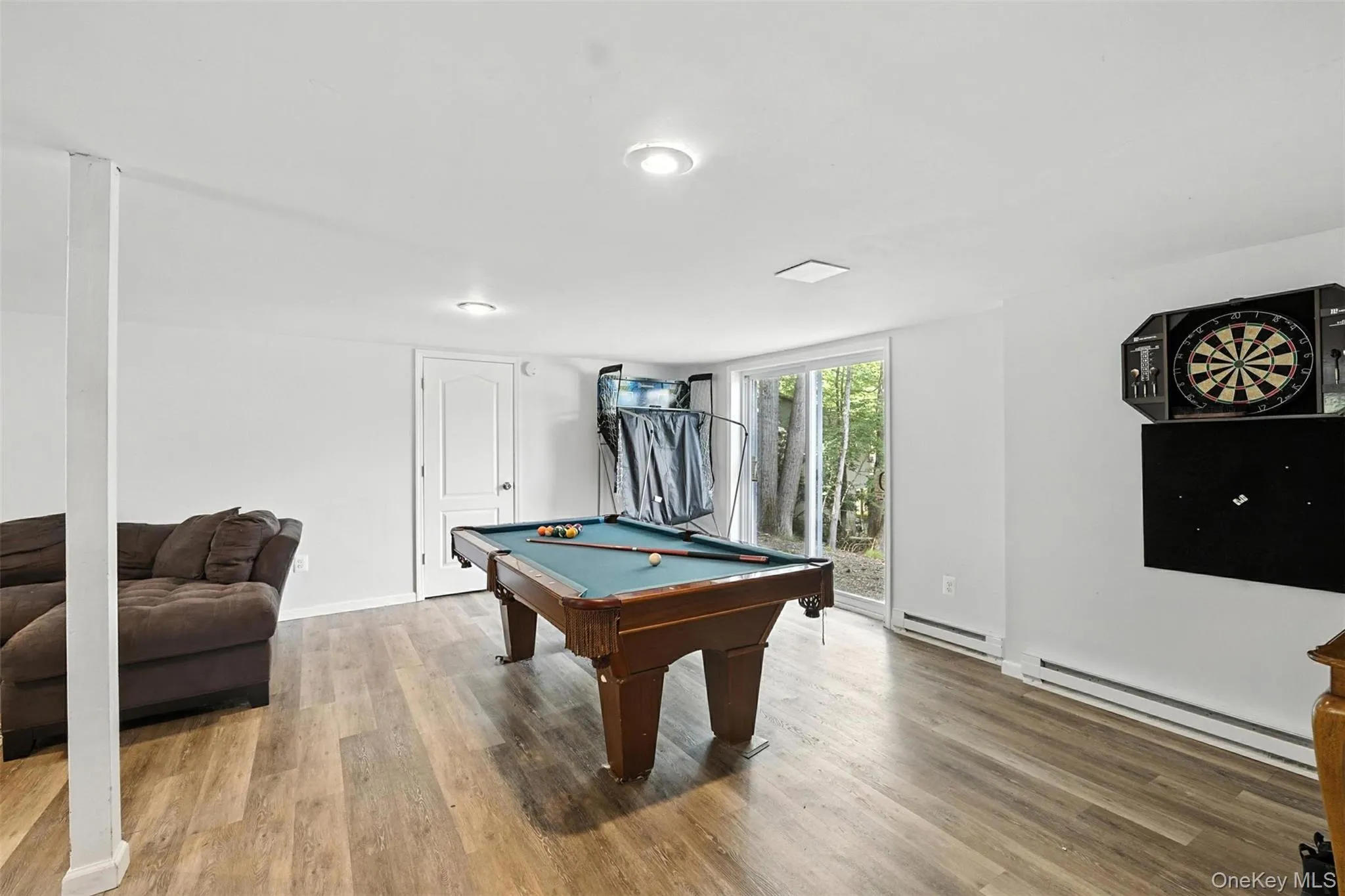 Rec room with a baseboard radiator, wood finished floors, and billiards table Rec room with a baseboard radiator, wood finished floors, and billiards table