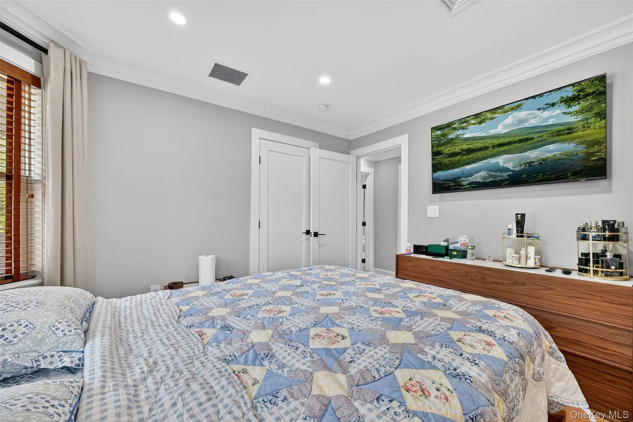 Recessed lighting illuminates the space, featuring white crown molding and light gray wall paint Recessed lighting illuminates the space, featuring white crown molding and light gray wall paint