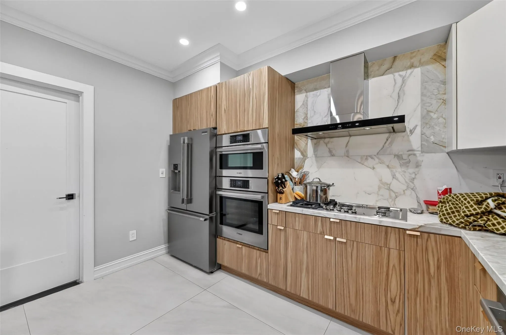 Modern kitchen featuring a stainless steel refrigerator, double wall ovens, and a gas cooktop Modern kitchen featuring a stainless steel refrigerator, double wall ovens, and a gas cooktop