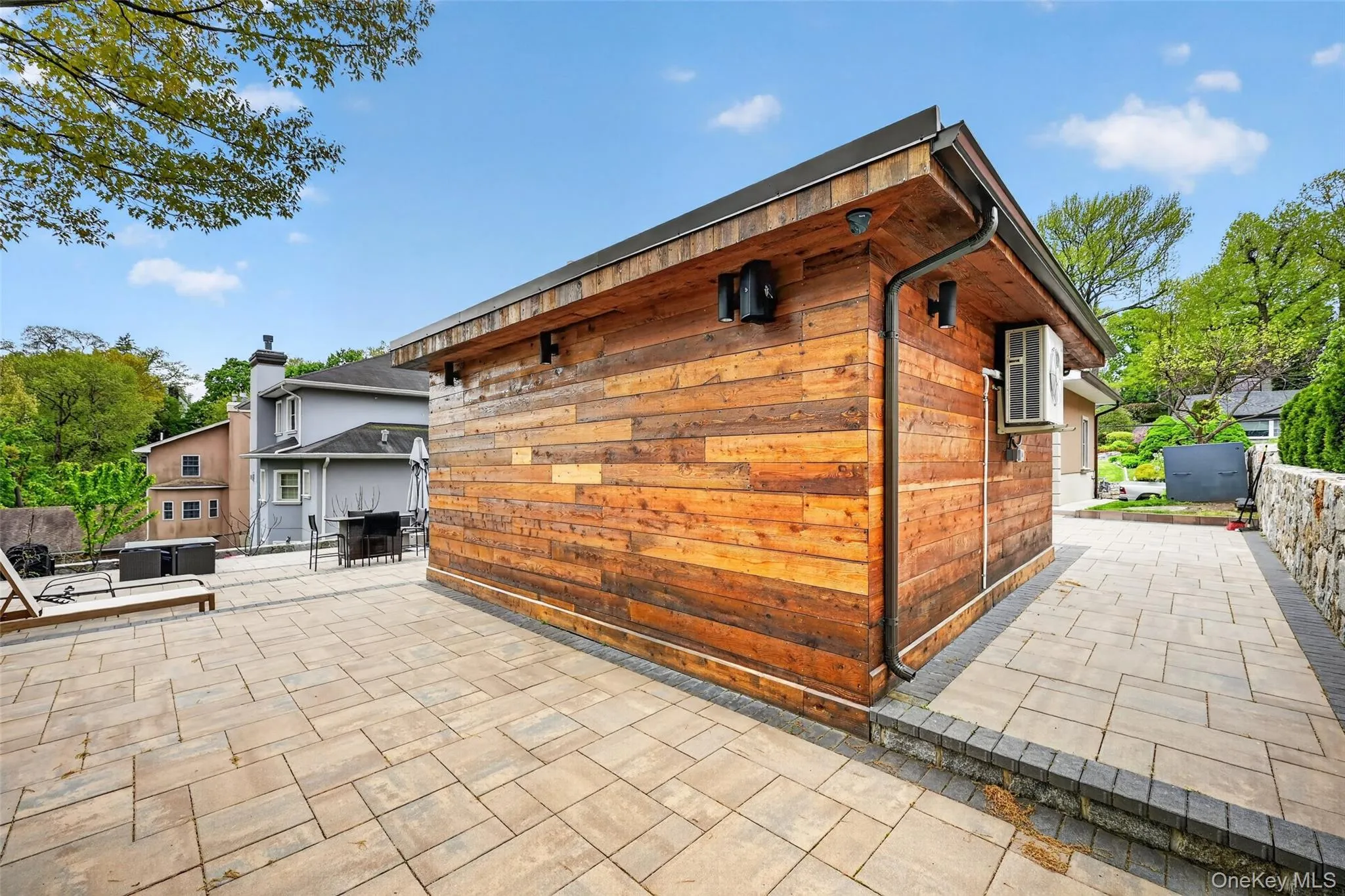 Outdoor structure with wood-finish siding, dark trim, and integrated gutters Outdoor structure with wood-finish siding, dark trim, and integrated gutters