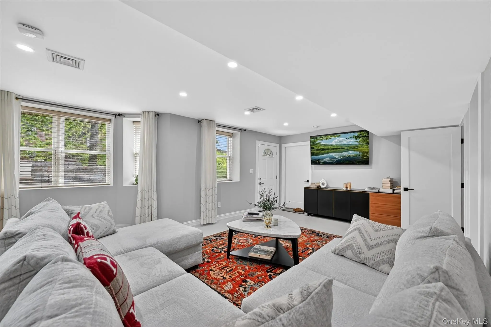 Spacious living area featuring light gray walls and recessed lighting Spacious living area featuring light gray walls and recessed lighting