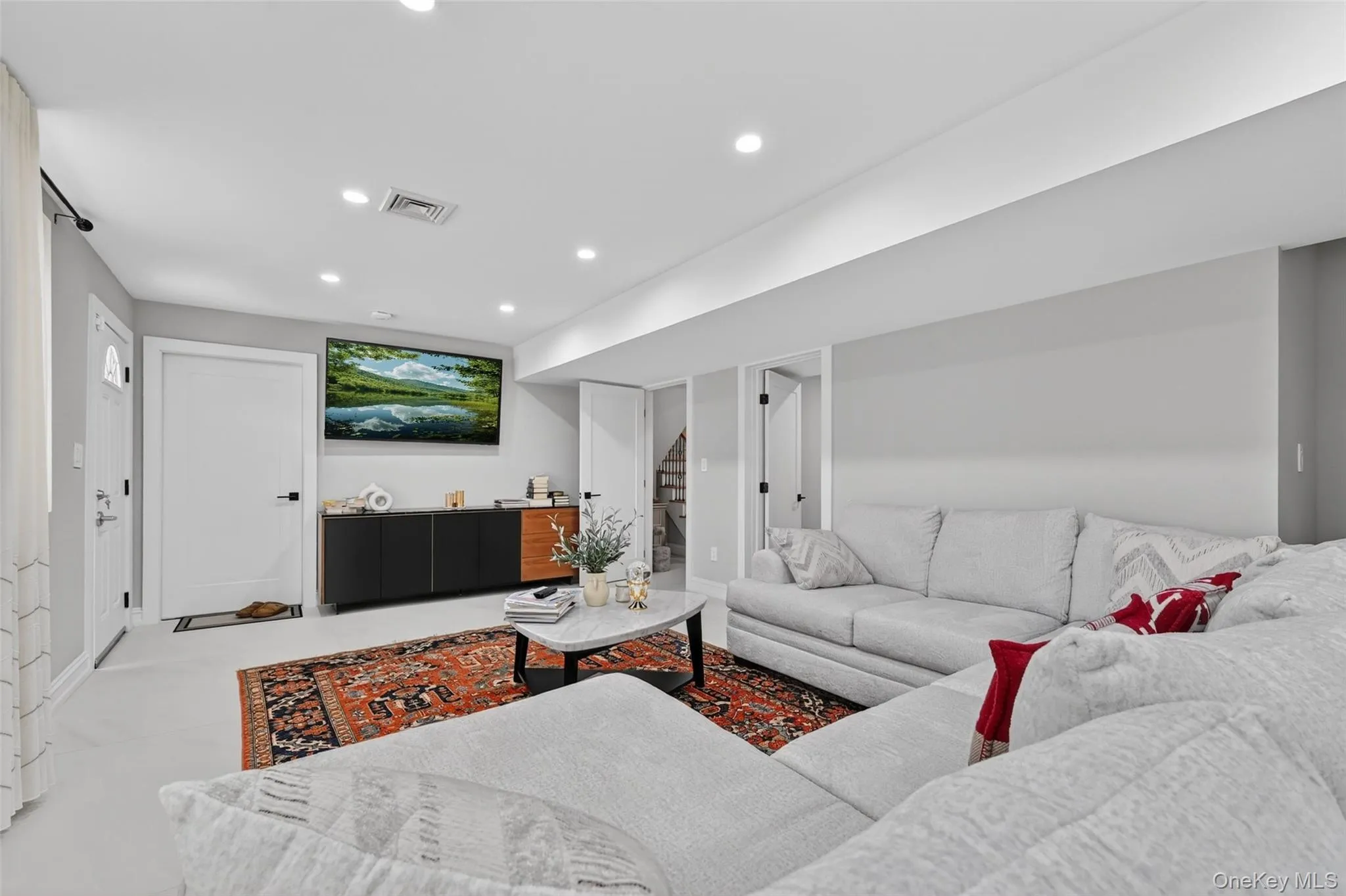 Spacious living area featuring light-colored flooring, recessed lighting, and crisp white trim Spacious living area featuring light-colored flooring, recessed lighting, and crisp white trim