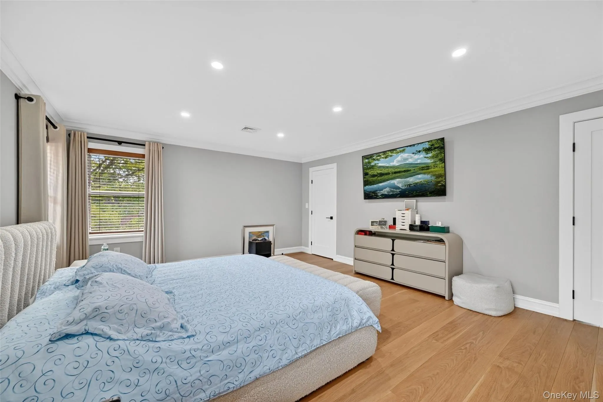 Spacious room featuring wood-finish flooring, recessed lighting, and crown molding Spacious room featuring wood-finish flooring, recessed lighting, and crown molding