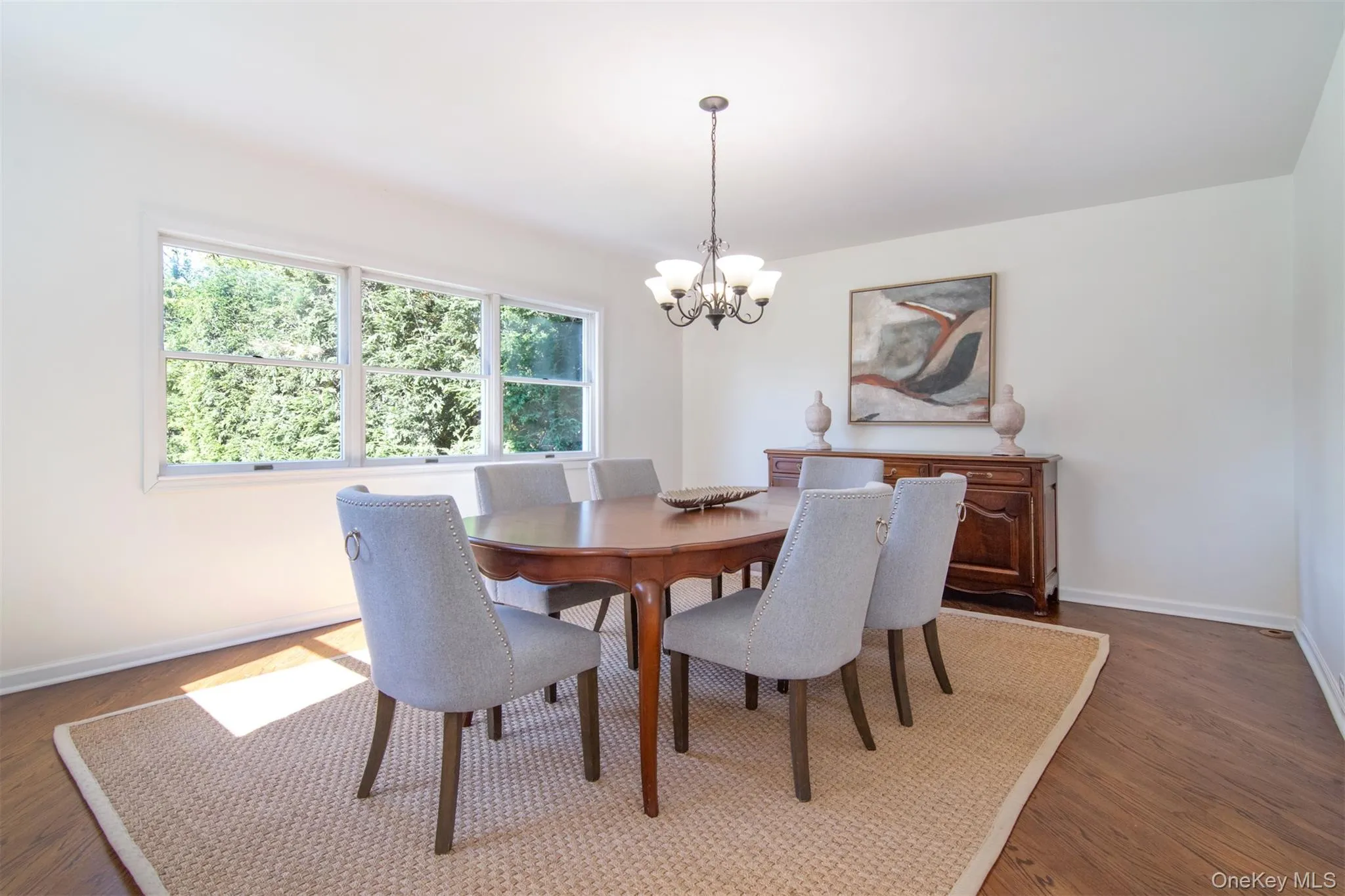 Dining area with a chandelier and dark wood-style flooring Dining area with a chandelier and dark wood-style flooring