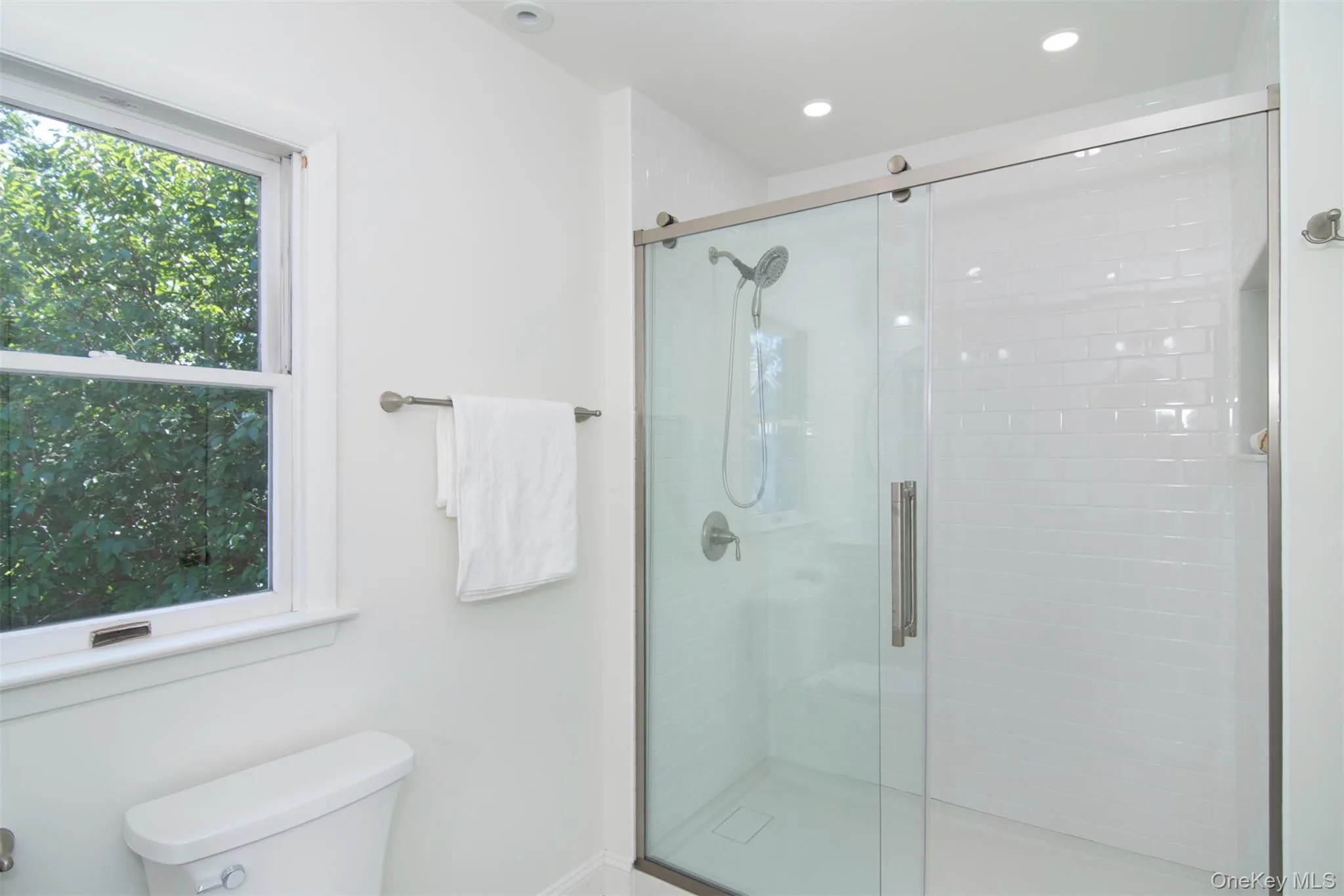 Full bath featuring a stall shower and toilet Full bath featuring a stall shower and toilet