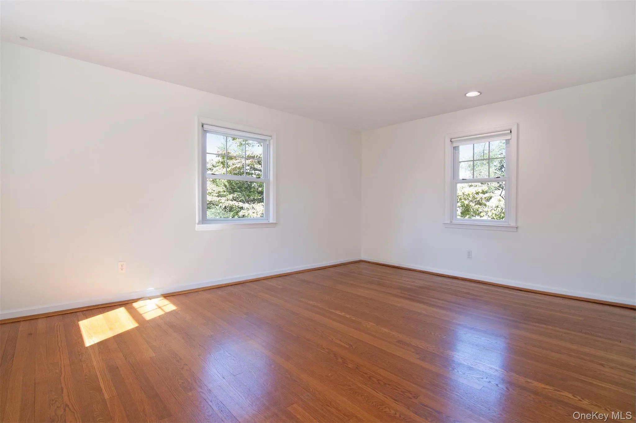 Empty room featuring wood finished floors and recessed lighting Empty room featuring wood finished floors and recessed lighting