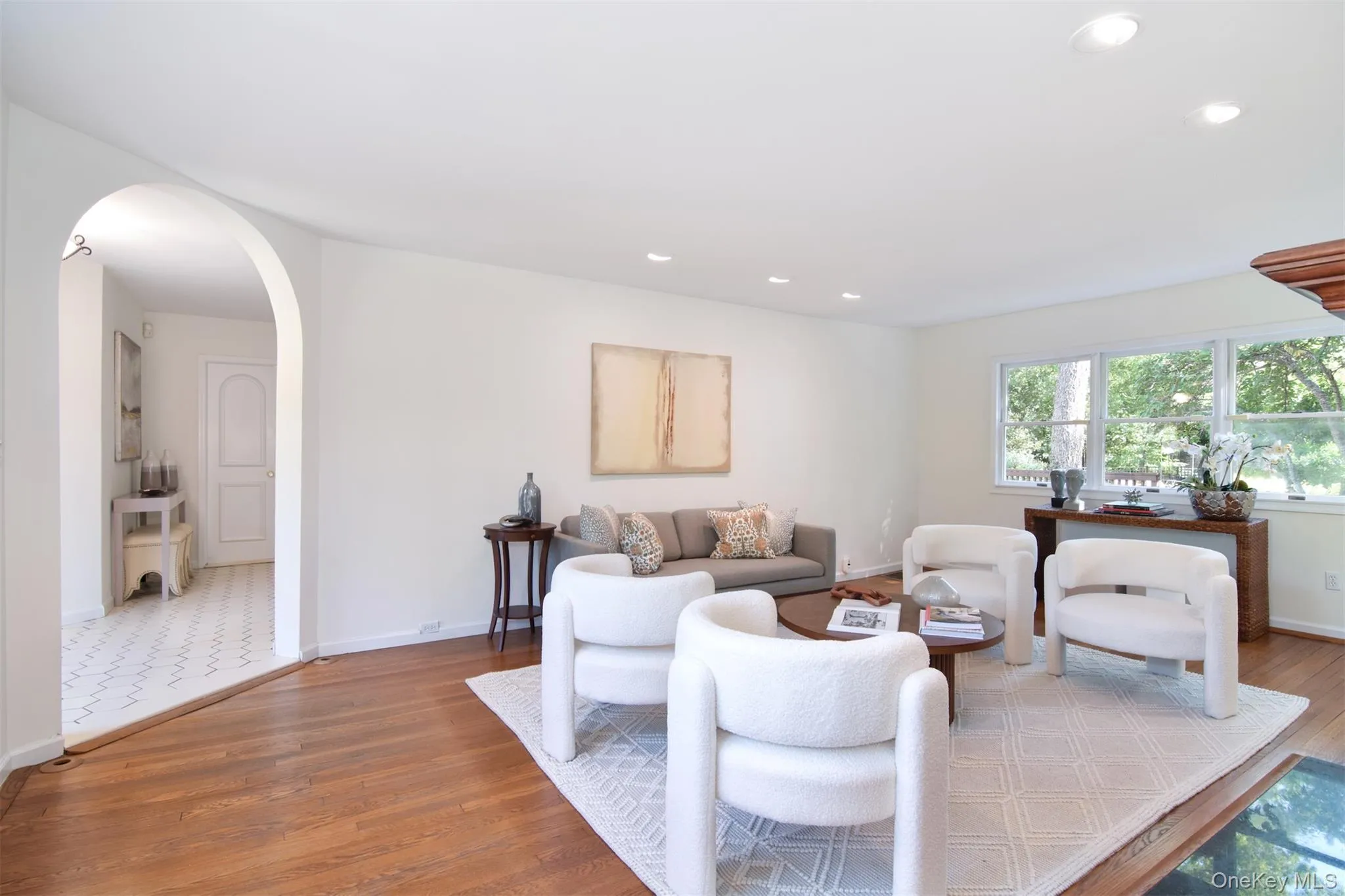 Living area featuring wood finished floors, arched walkways, and recessed lighting Living area featuring wood finished floors, arched walkways, and recessed lighting