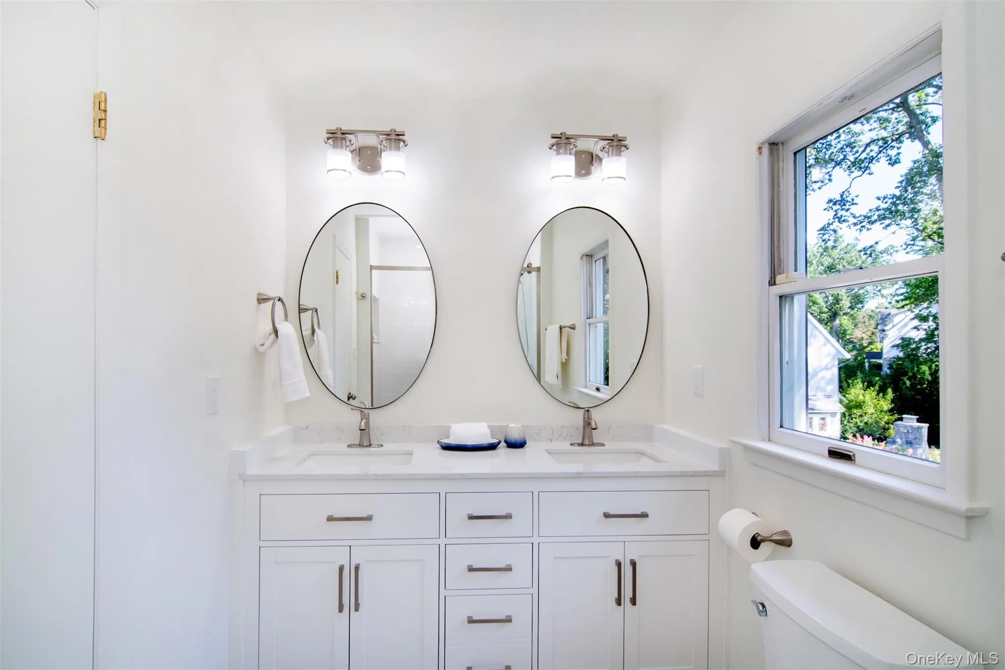 Full bathroom featuring double vanity and a shower Full bathroom featuring double vanity and a shower
