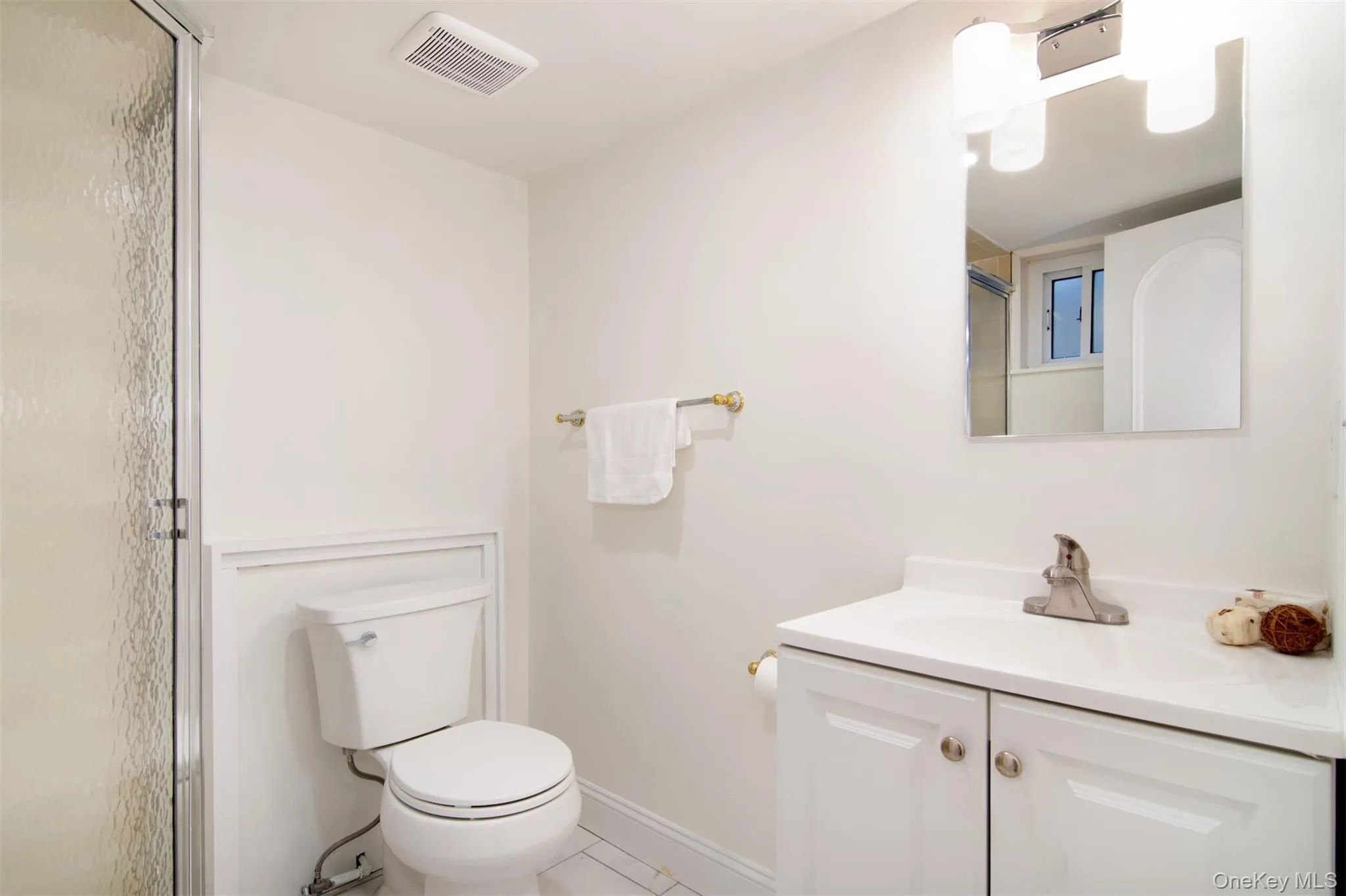 Full bathroom with vanity, light tile patterned floors, and a shower with door Full bathroom with vanity, light tile patterned floors, and a shower with door