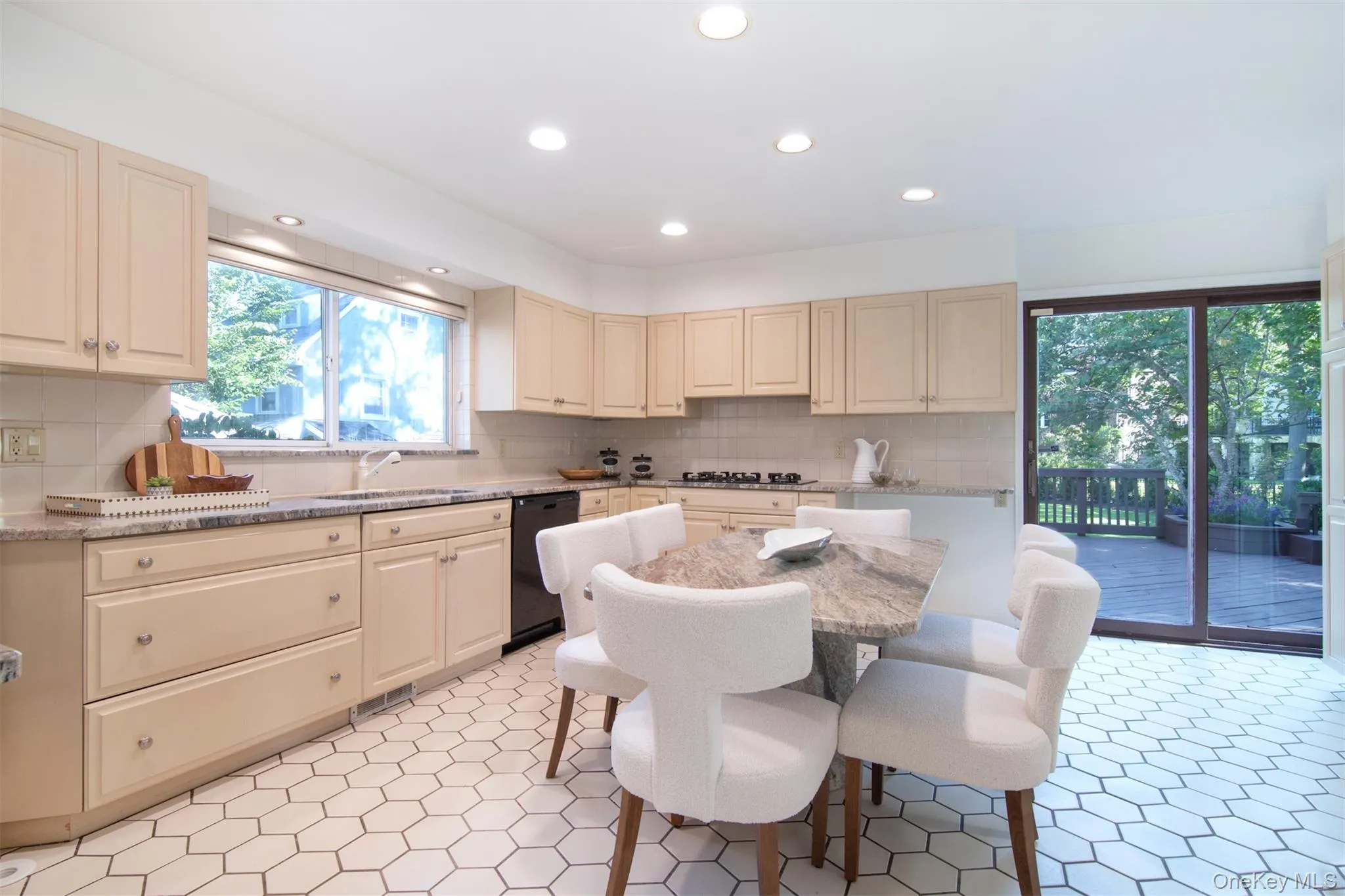 Kitchen featuring light stone countertops, cream cabinets, recessed lighting, and backsplash Kitchen featuring light stone countertops, cream cabinets, recessed lighting, and backsplash