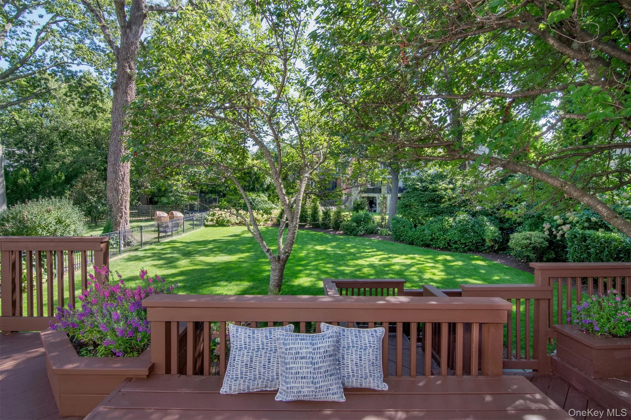 Wooden deck featuring a fenced backyard and view of wooded area Wooden deck featuring a fenced backyard and view of wooded area