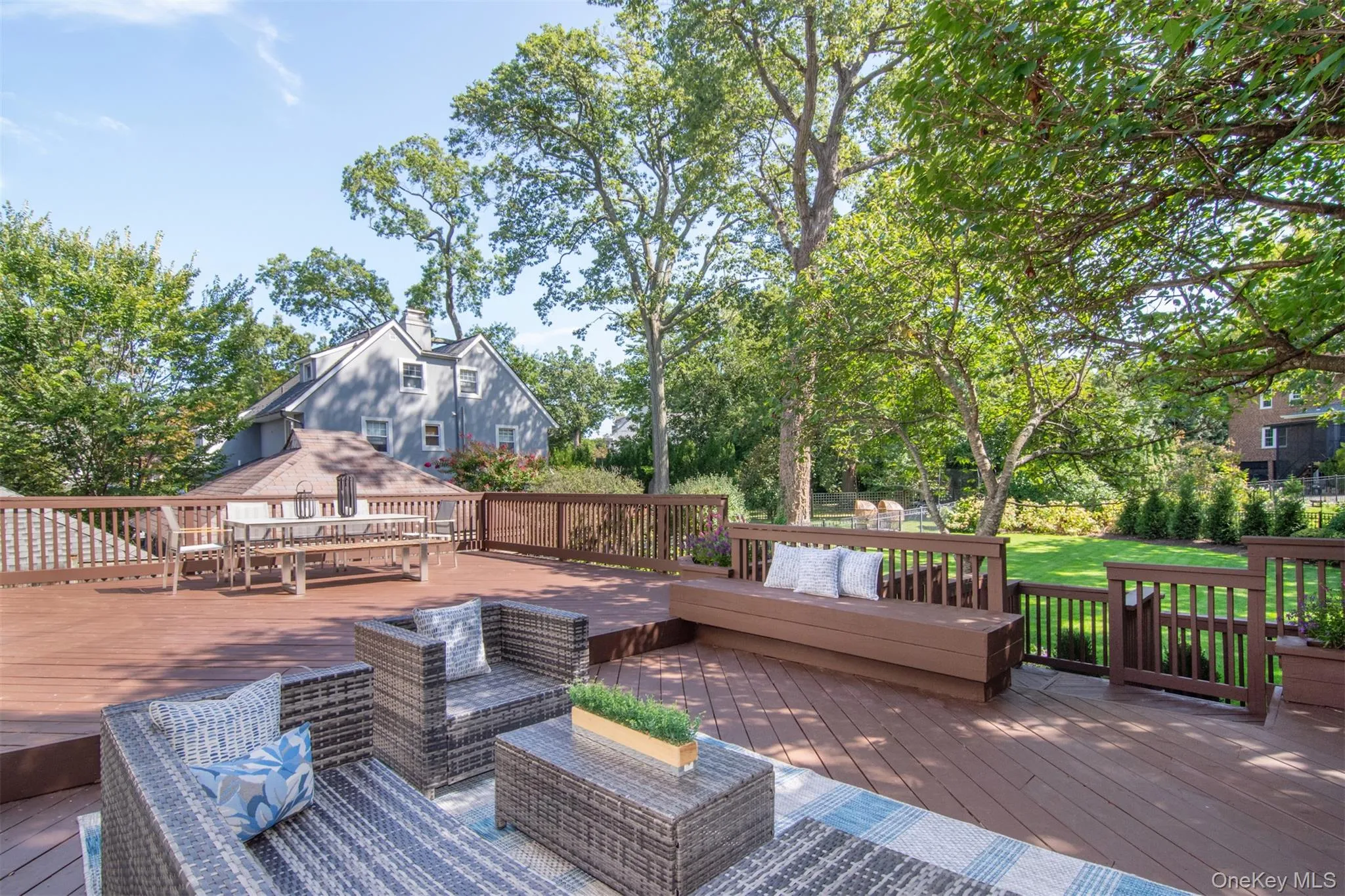 Wooden terrace featuring view of wooded area and an outdoor hangout area Wooden terrace featuring view of wooded area and an outdoor hangout area