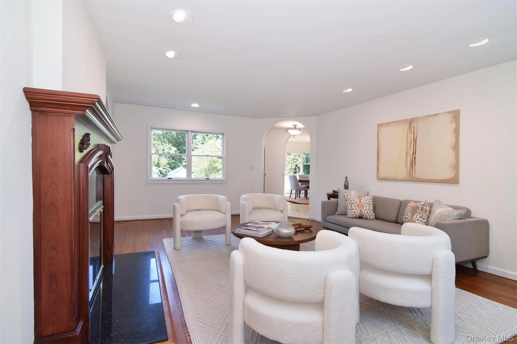 Living room with arched walkways, wood finished floors, and recessed lighting Living room with arched walkways, wood finished floors, and recessed lighting
