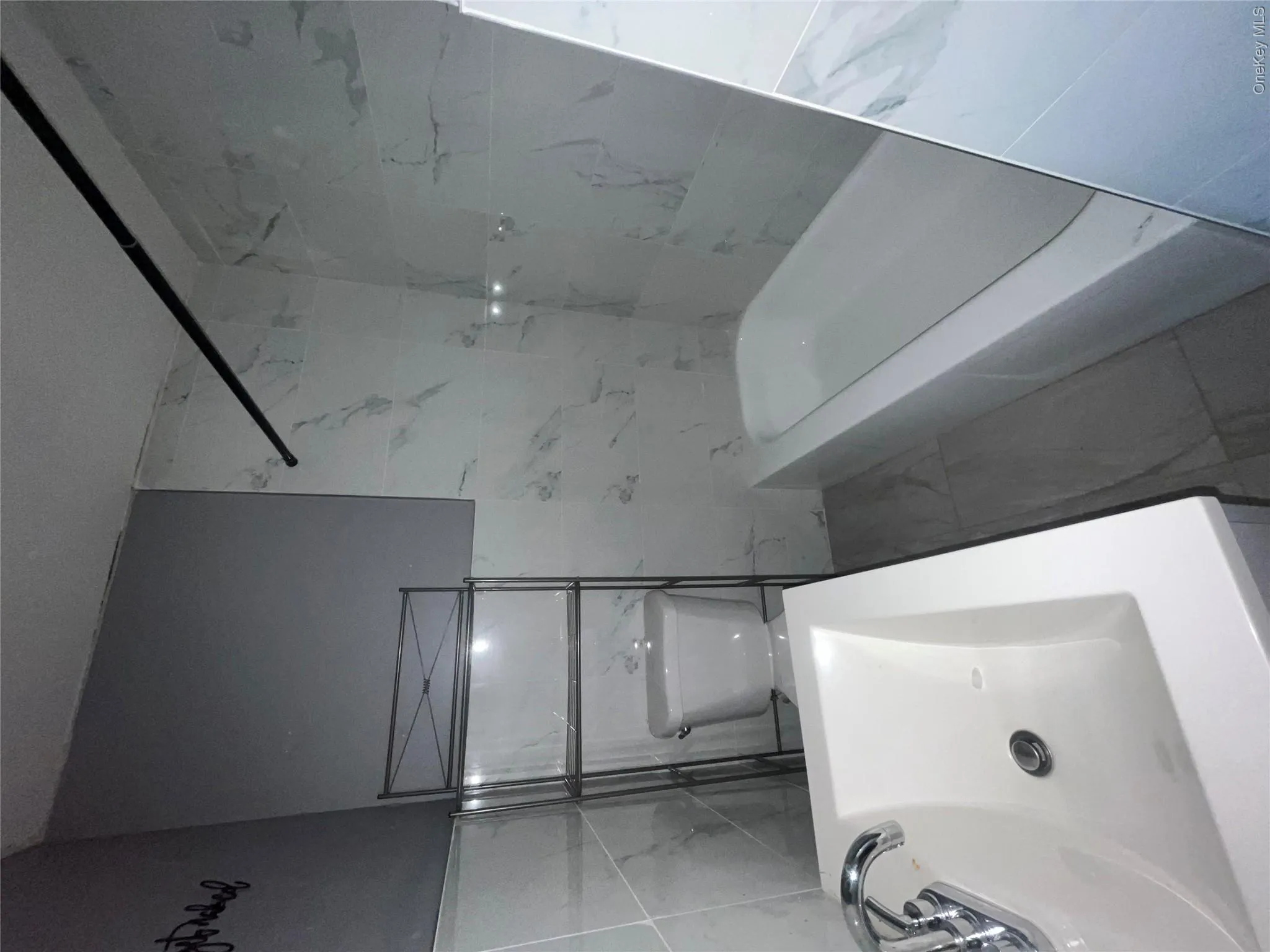 Bathroom with tile walls, marble finish floors, and tub / shower combination Bathroom with tile walls, marble finish floors, and tub / shower combination