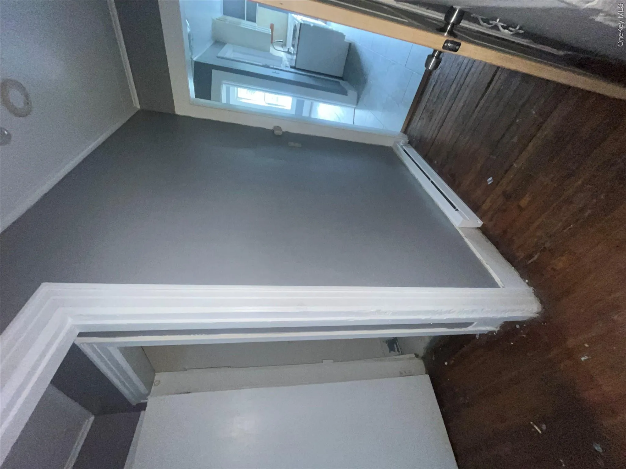 Hallway with a baseboard radiator, wood finished floors, and crown molding Hallway with a baseboard radiator, wood finished floors, and crown molding