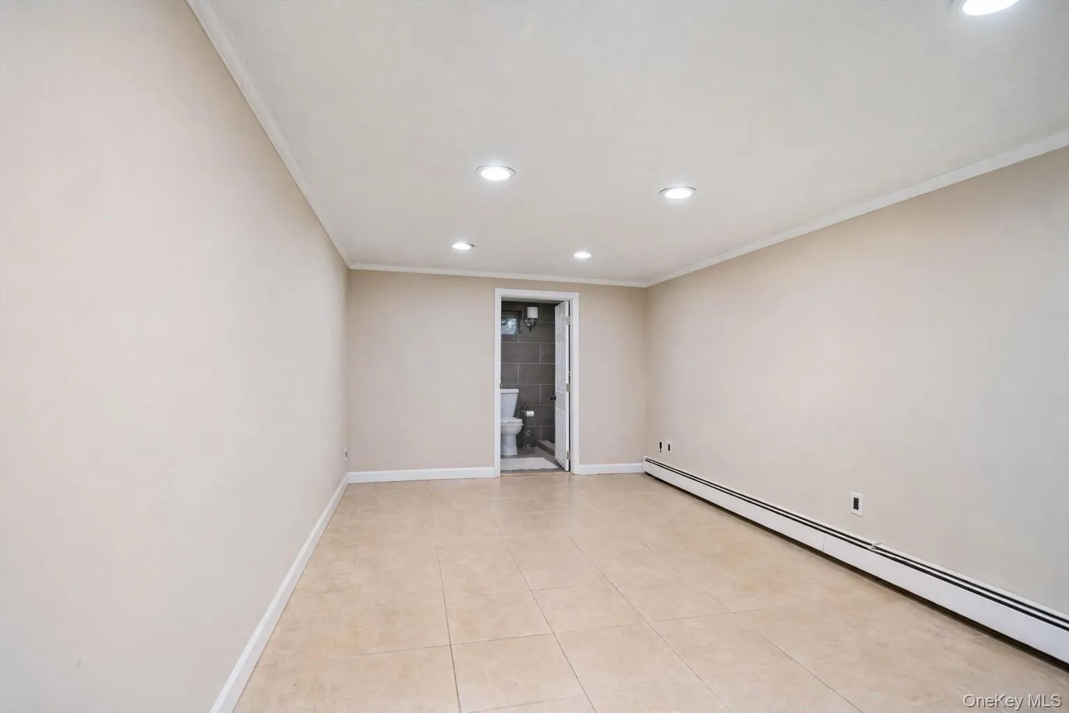 Spare room with baseboard heating, recessed lighting, light tile patterned floors, and crown molding Spare room with baseboard heating, recessed lighting, light tile patterned floors, and crown molding
