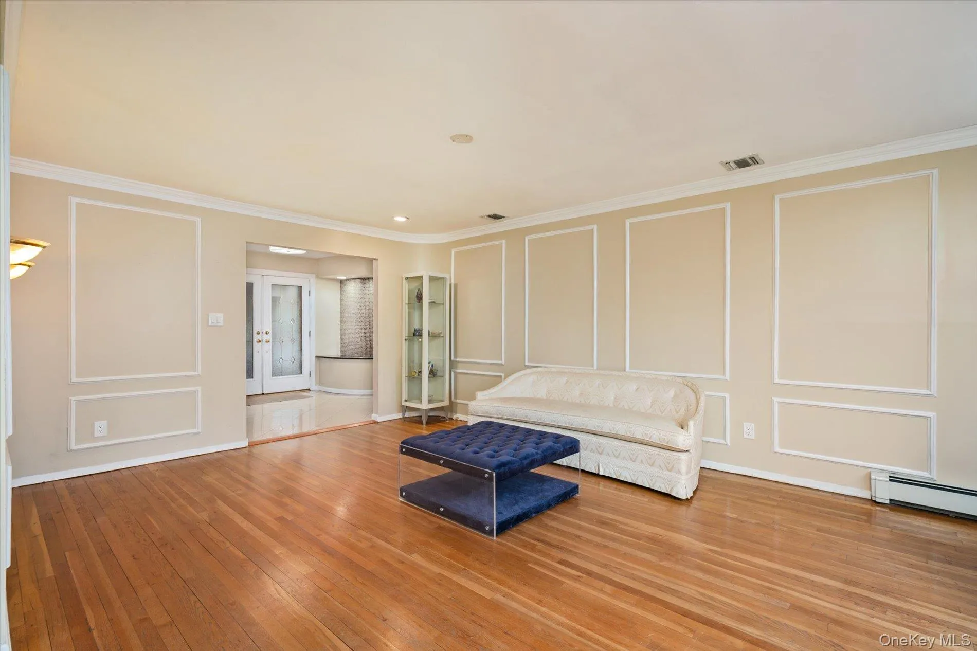 Unfurnished room with a decorative wall, hardwood / wood-style floors, french doors, and crown molding Unfurnished room with a decorative wall, hardwood / wood-style floors, french doors, and crown molding