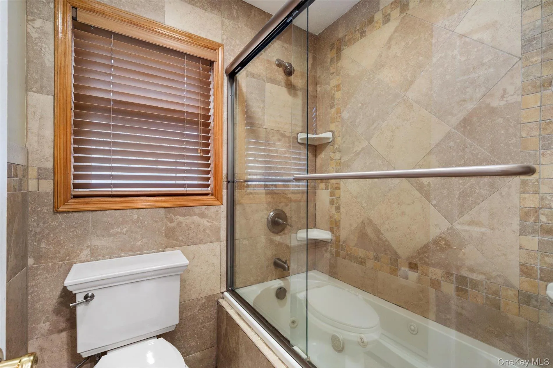 Bathroom with a combined bath / shower with jetted tub and tile walls Bathroom with a combined bath / shower with jetted tub and tile walls